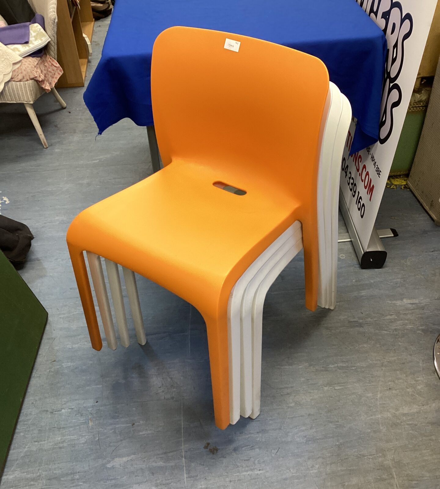 Four plastic reception chairs three white & one orange