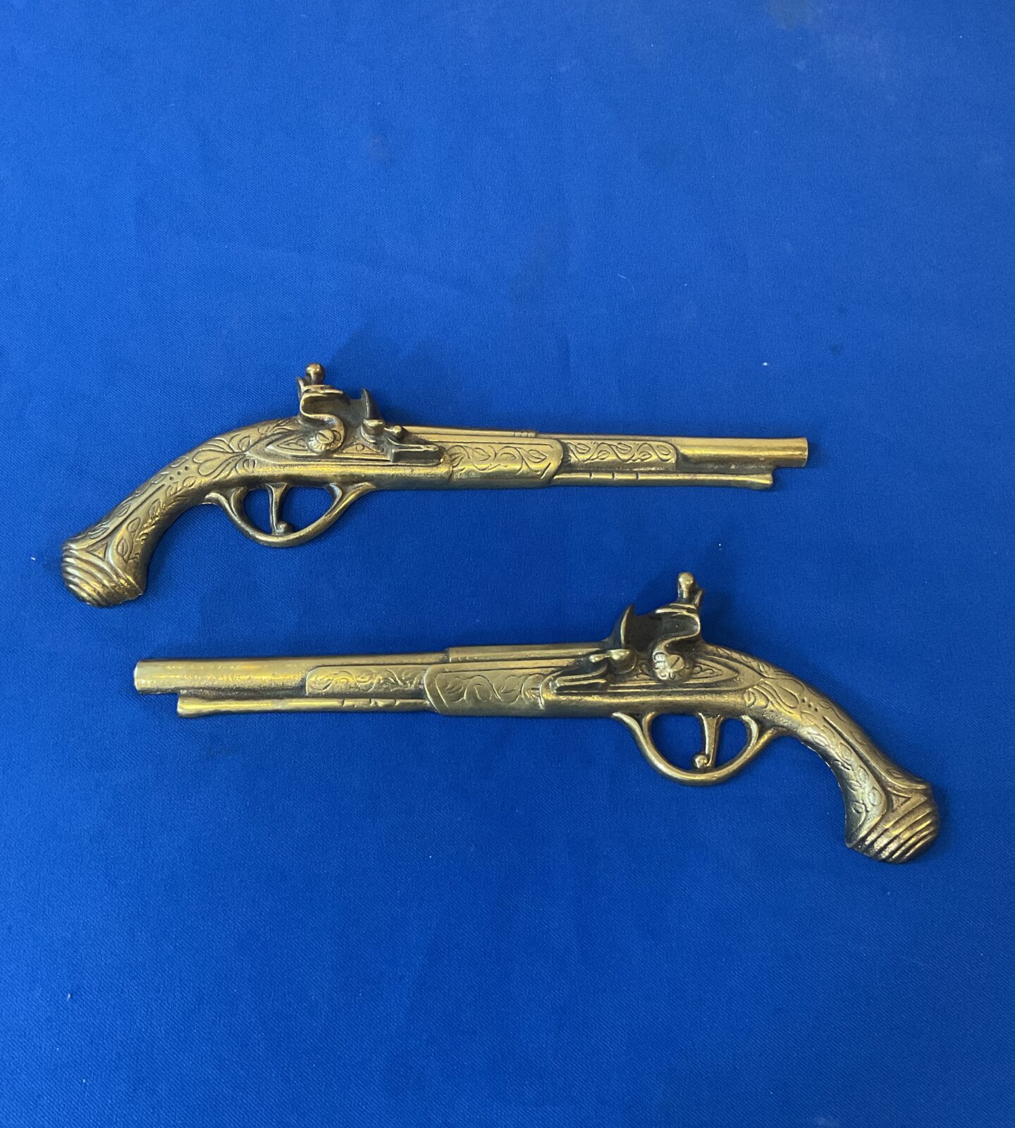Pair of brass wall hanging pistols