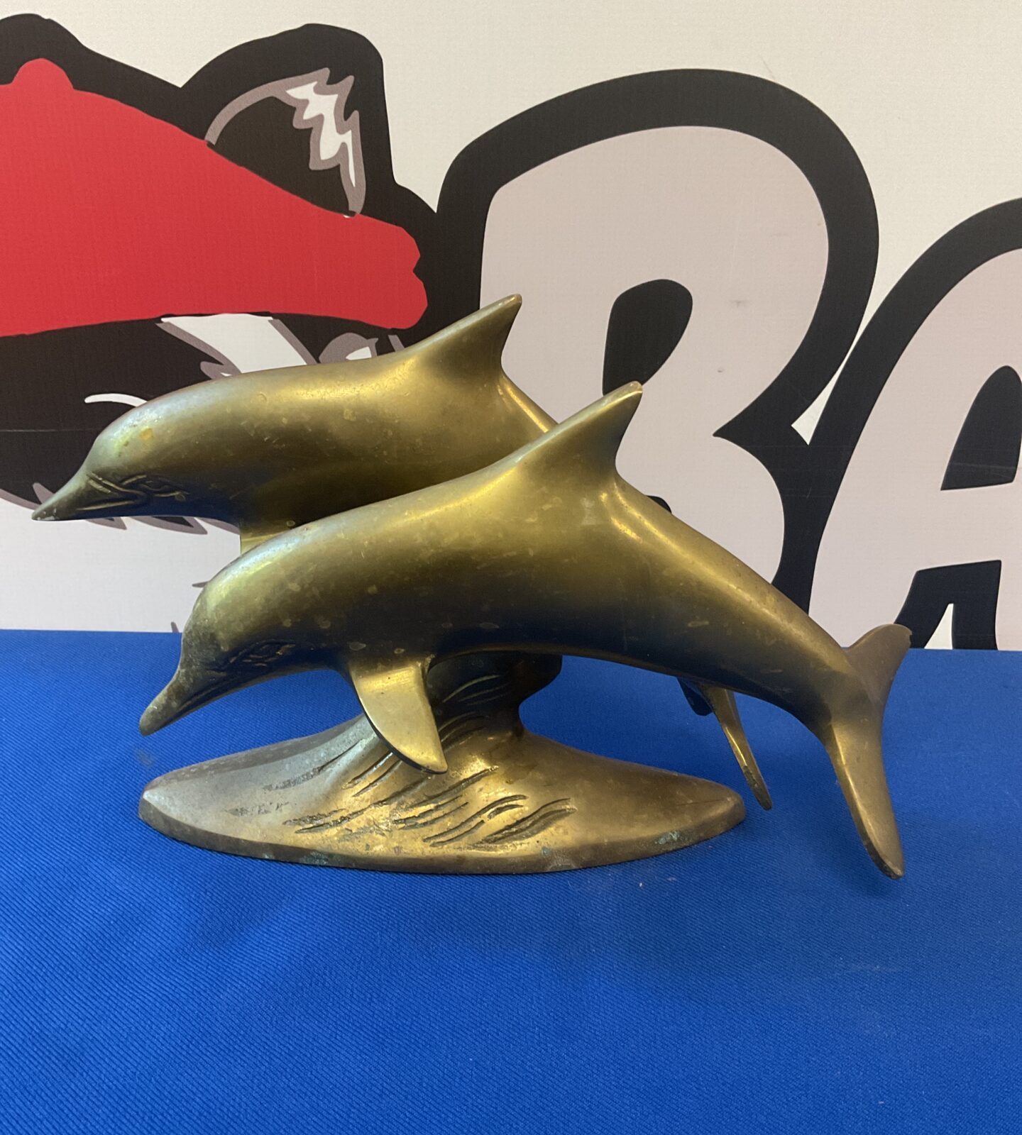 Brass ornament of leaping dolphins