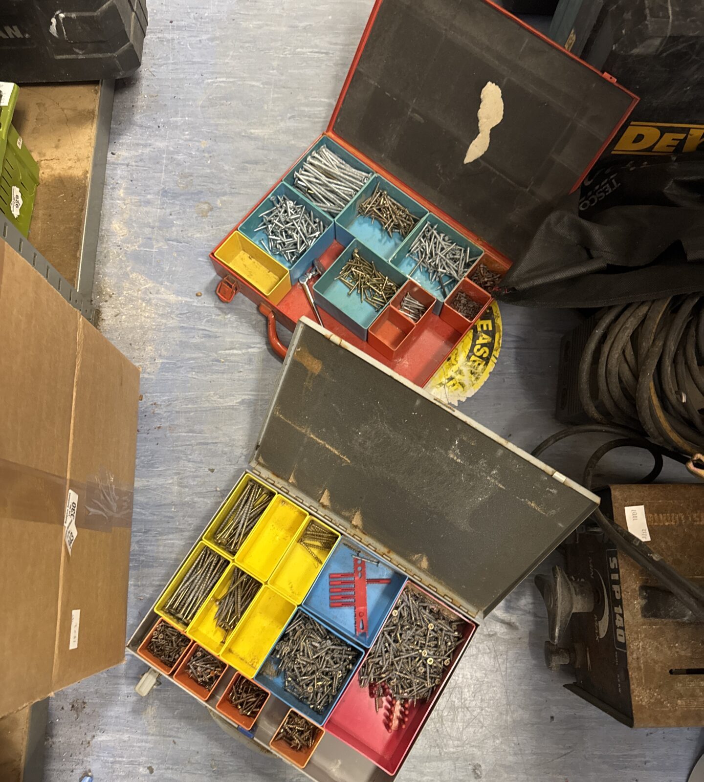 Two trays of assorted screws in trade cases