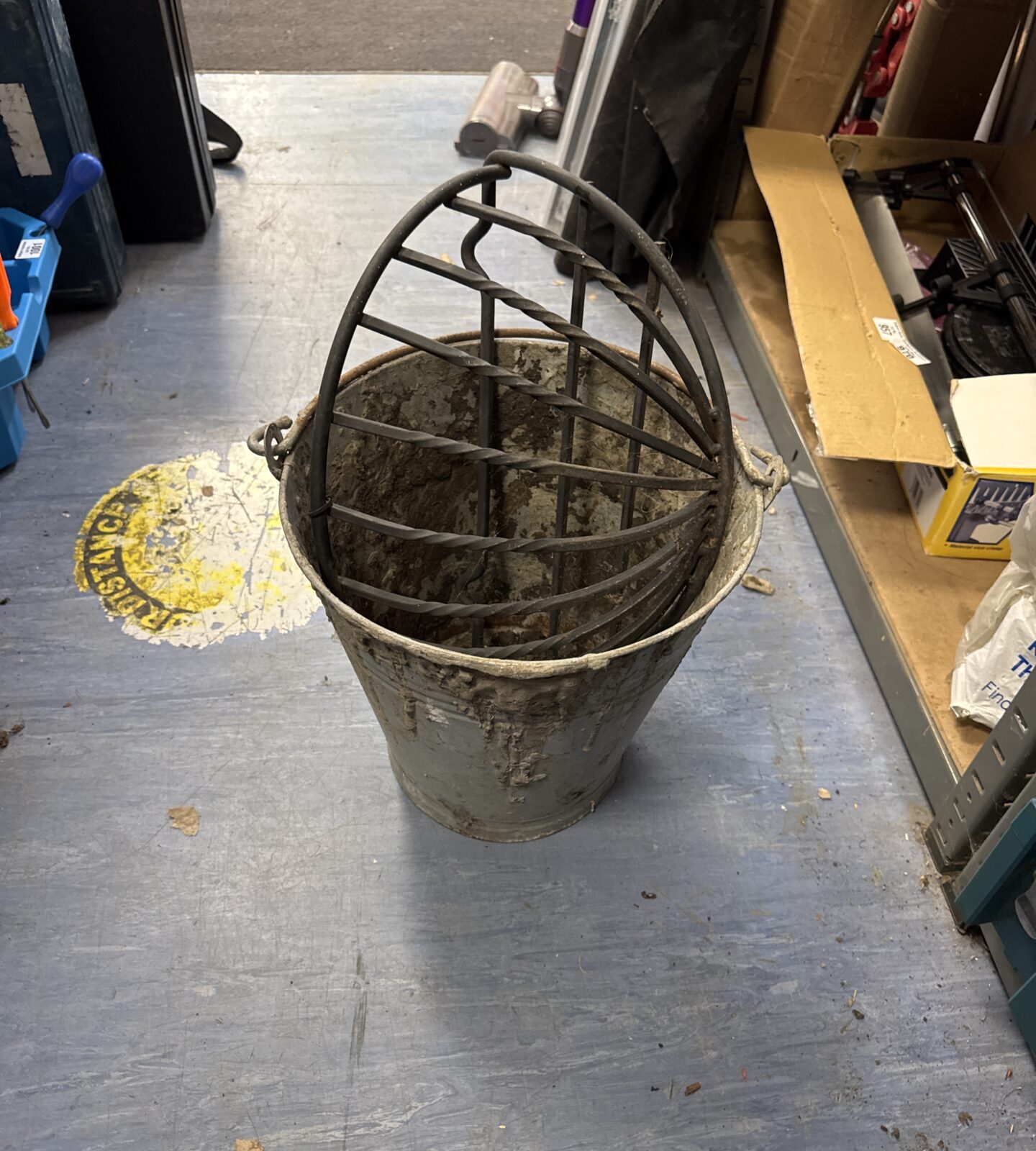 Vintage galvanised bucket (has dried cement on it) with a wrought iron wall flower basket