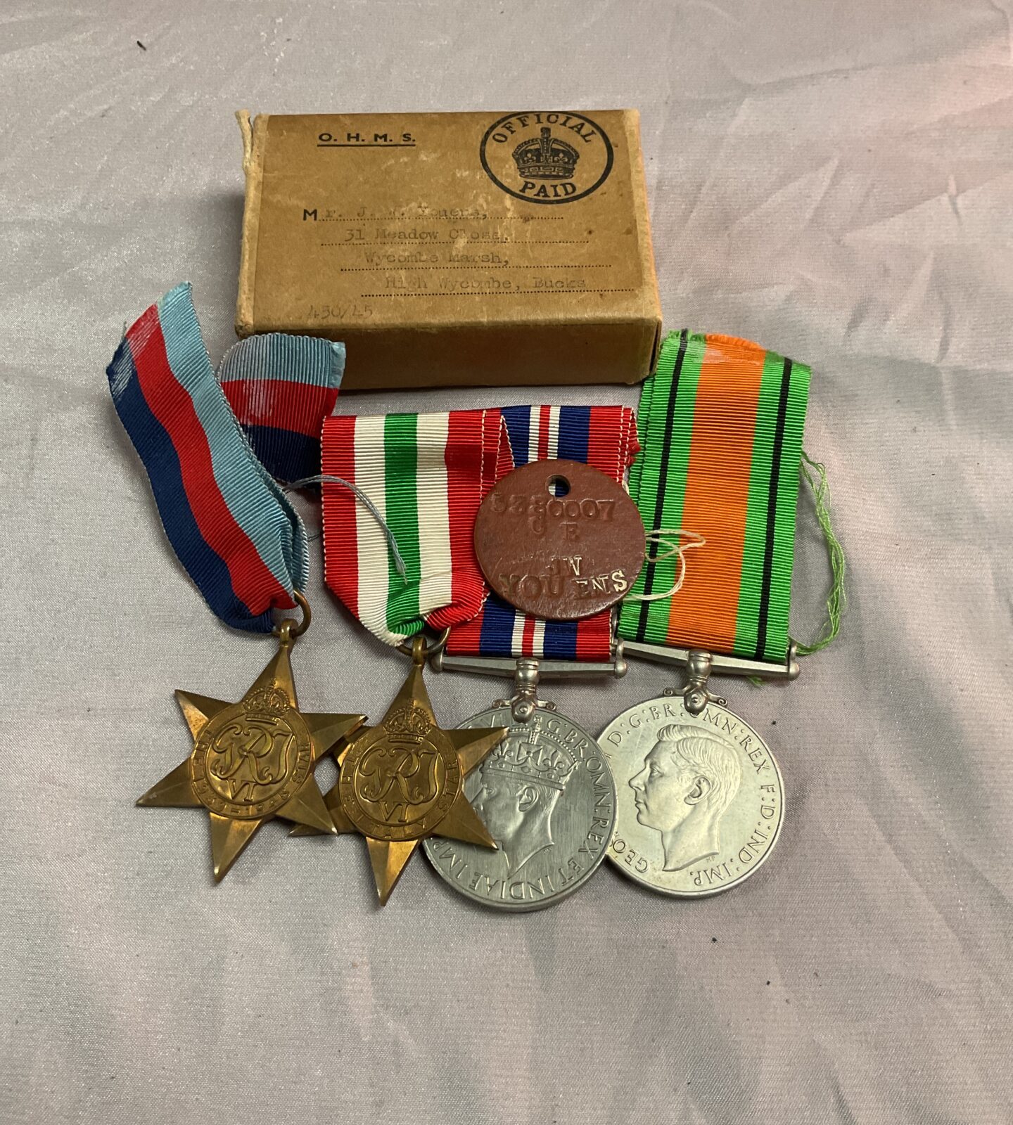 Four ww2 medals with dog tag and box named