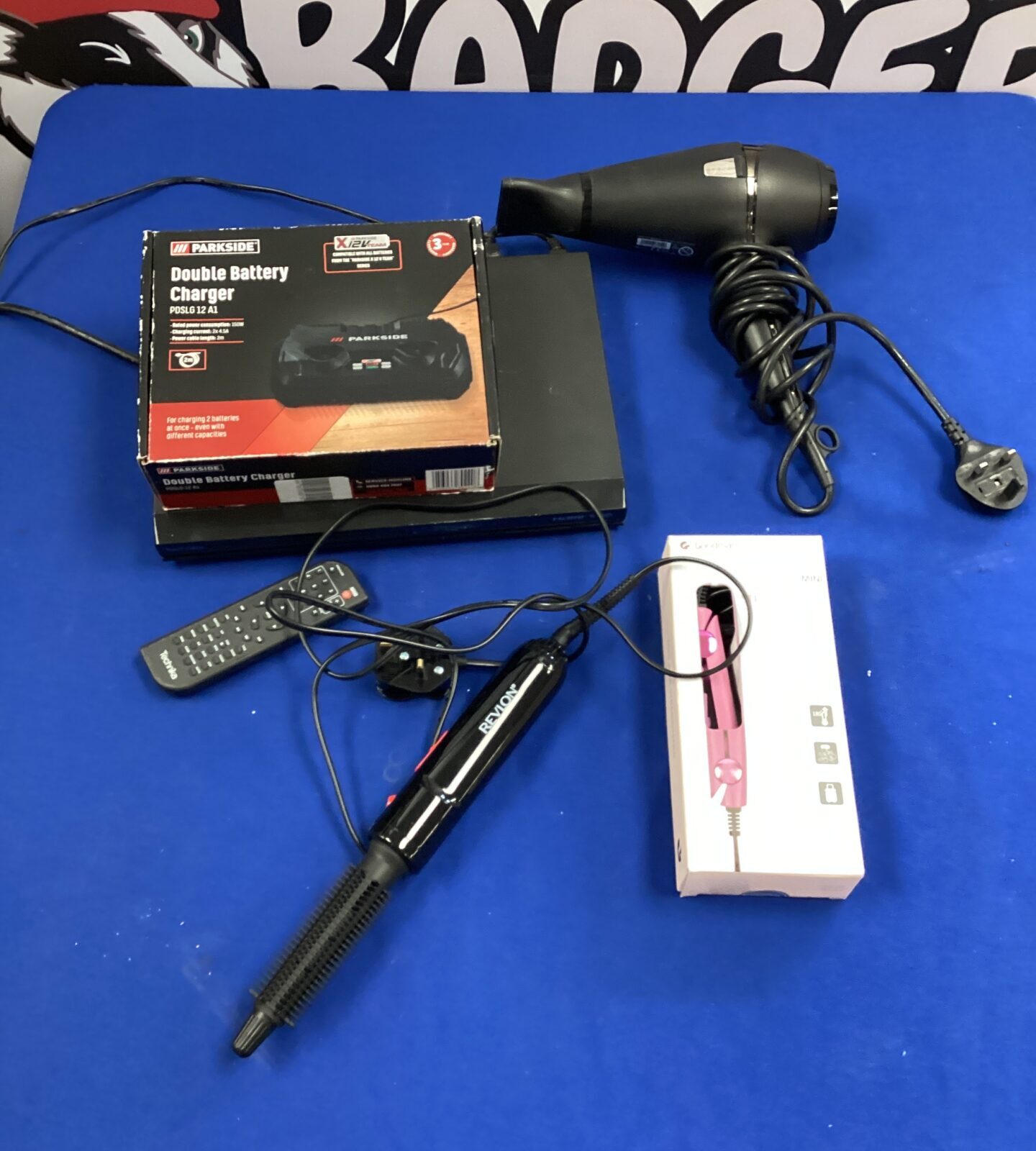 Box of mixed GHD hair dryer, goodmans hair straighteners & parkside double battery charger