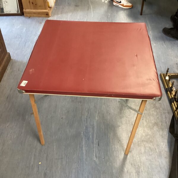 Vintage red folding card table with folding legs.