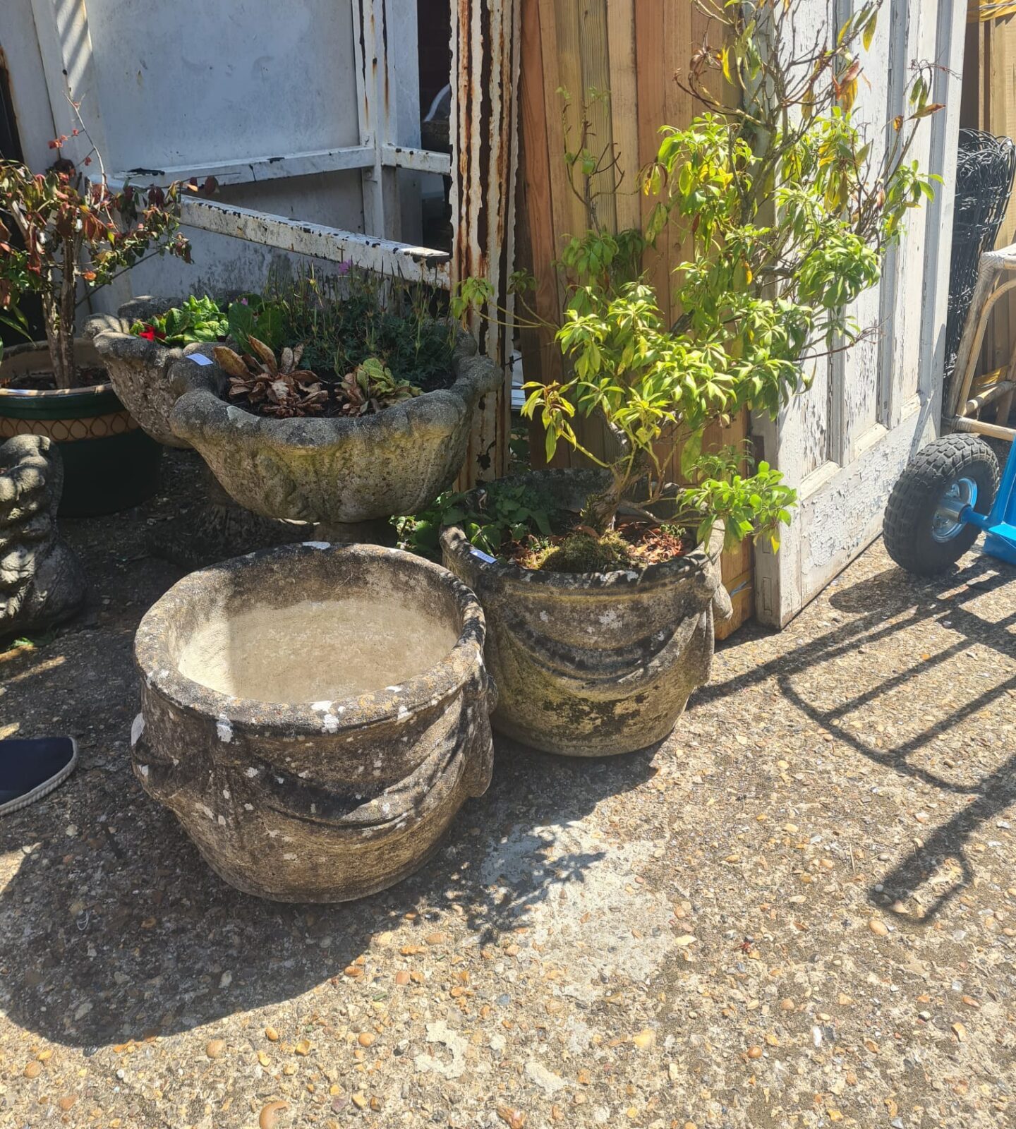 Two stone garden planters one empty