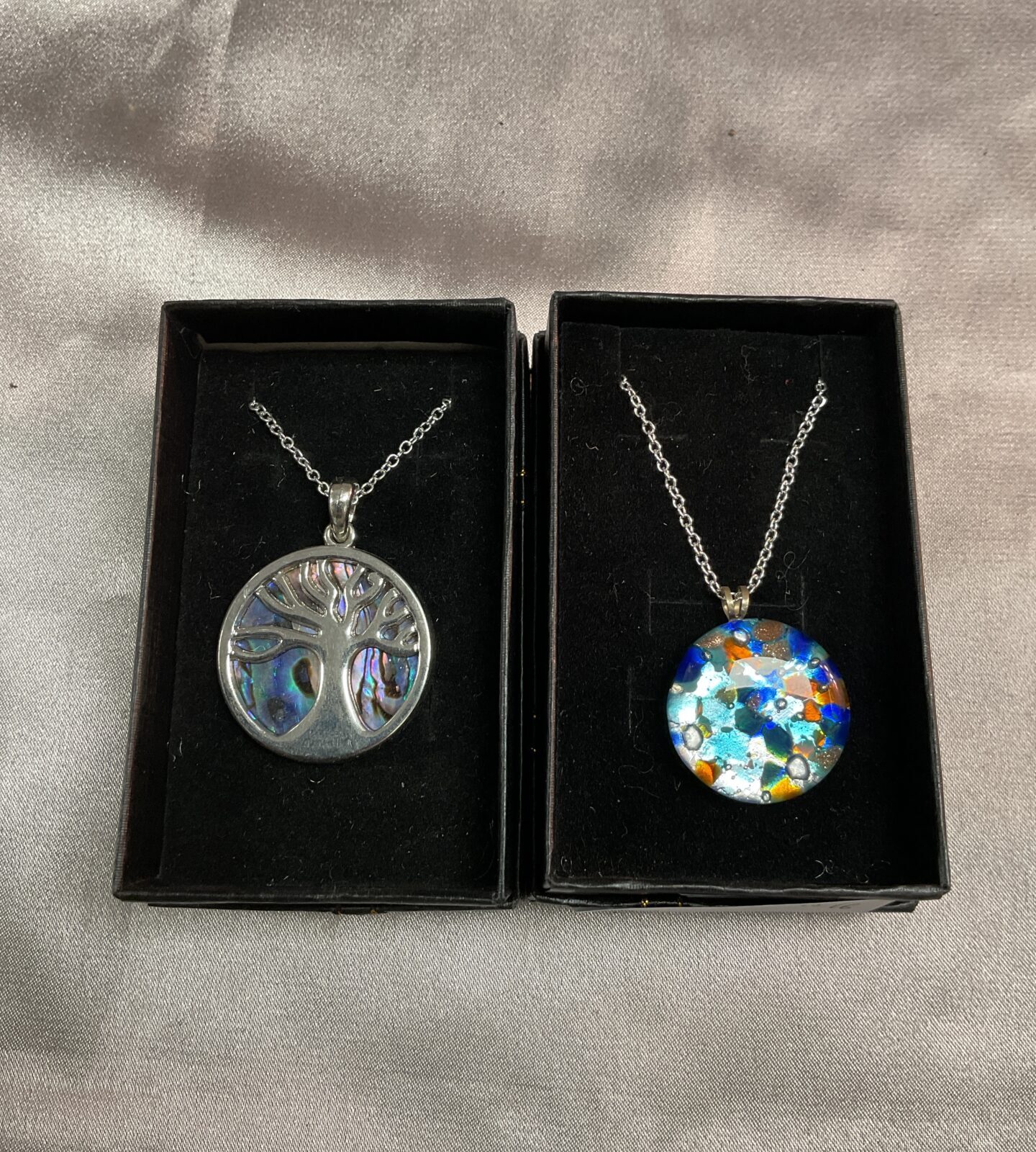 two shell pendants on silver  necklaces