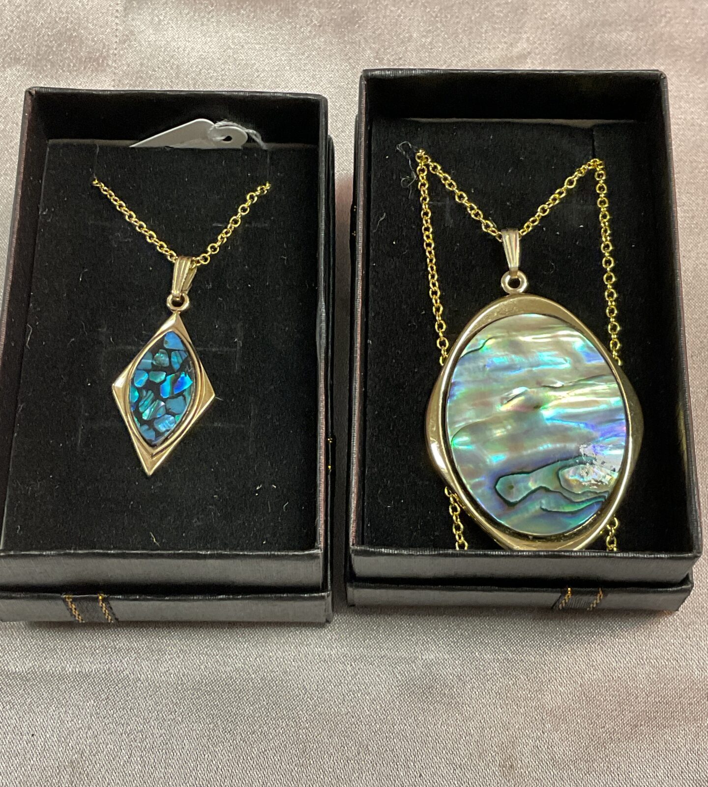 Two silver gilt necklaces with shell pendants