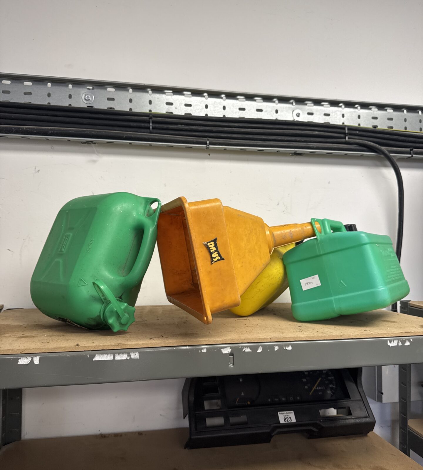 Three plastic Jerry cans with a large funnel