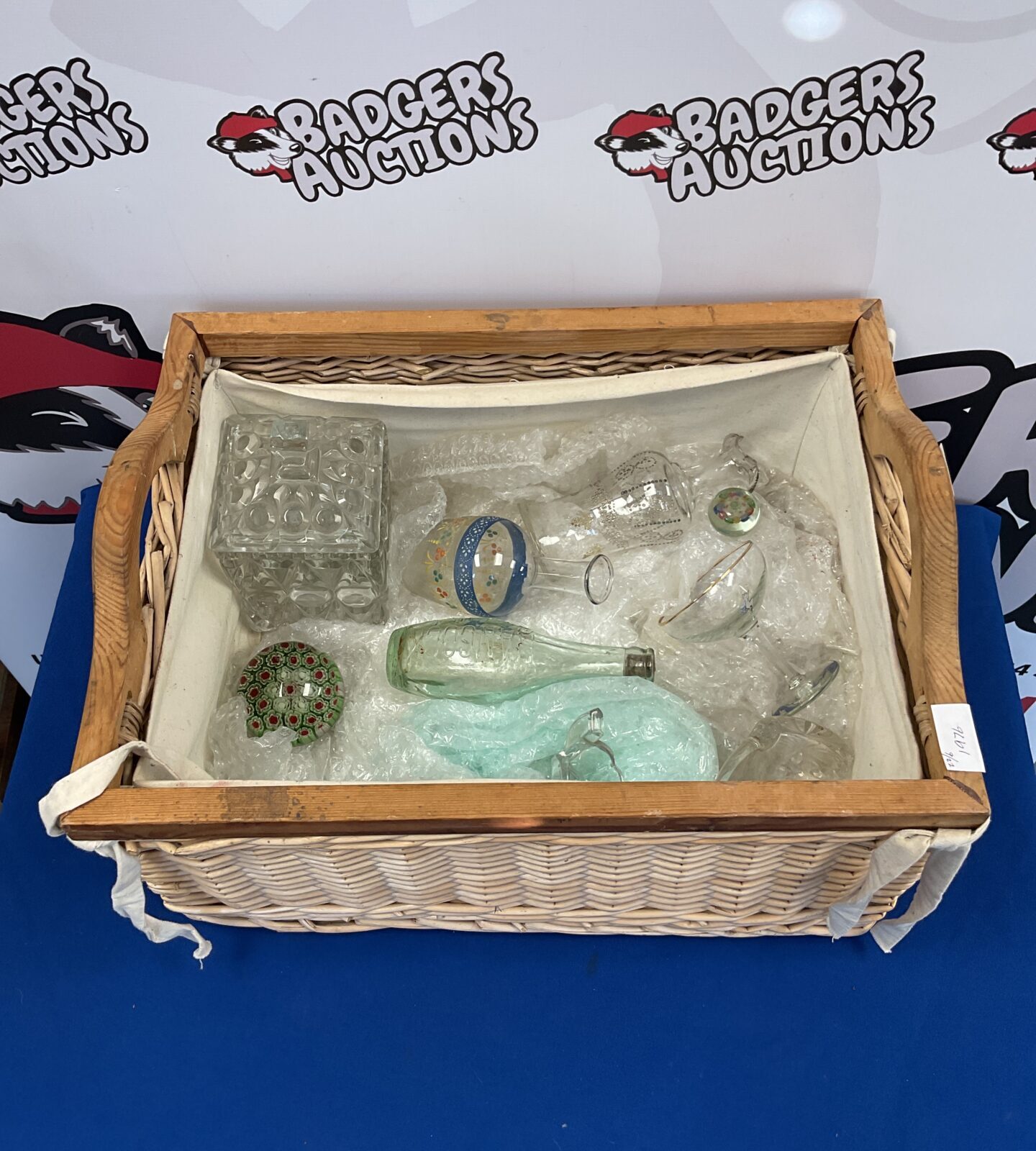 Wicker basket of vintage glassware including paperweights & hancock bottle