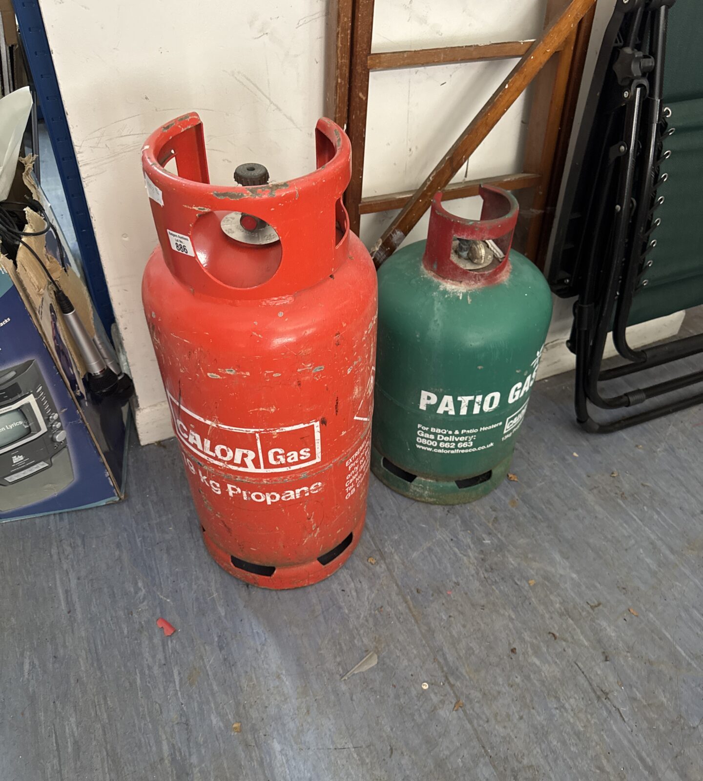 Two patio gas canisters - orange one has some contents, green showing empty