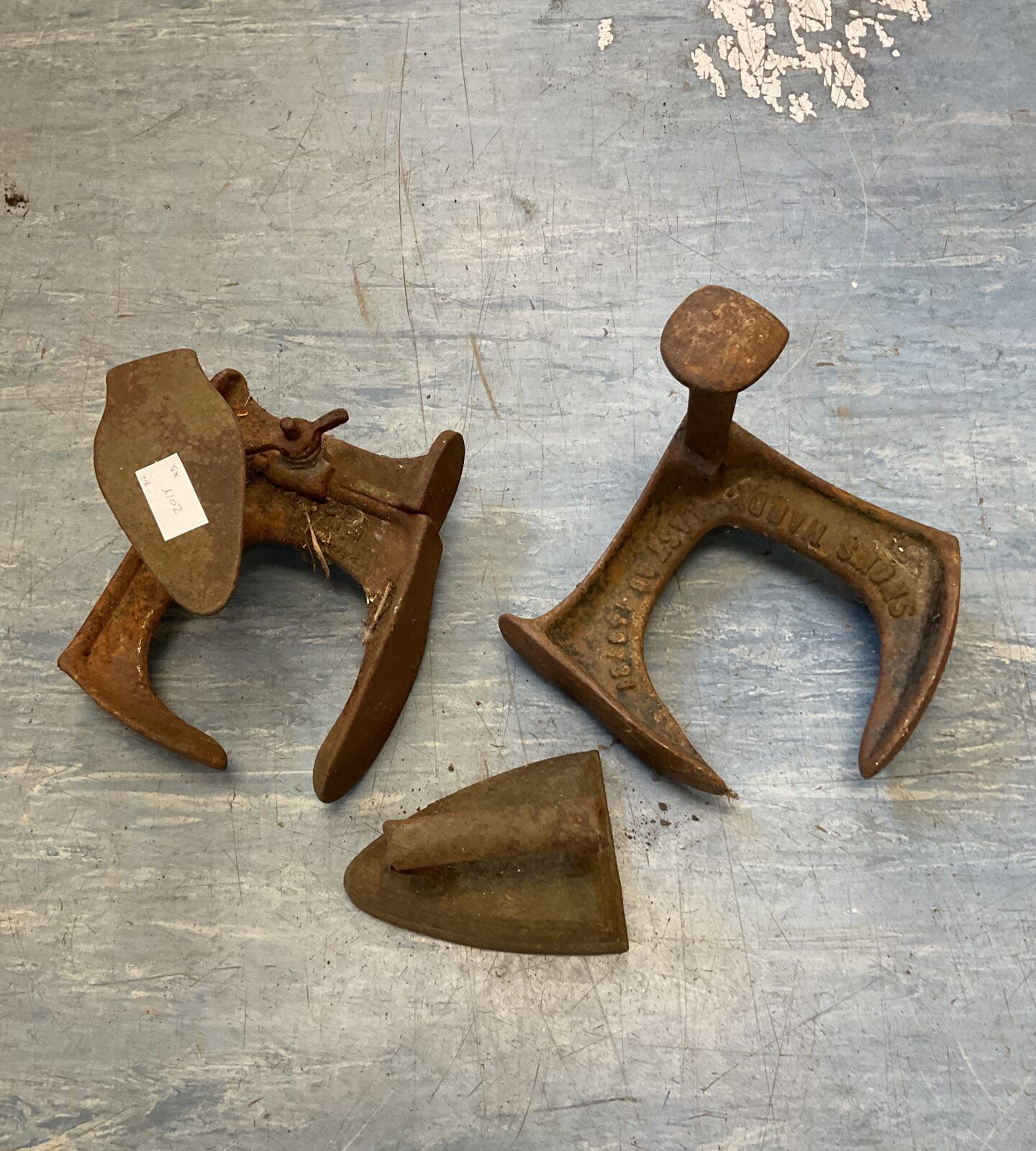 Two cast iron shoe lasts & flat iron