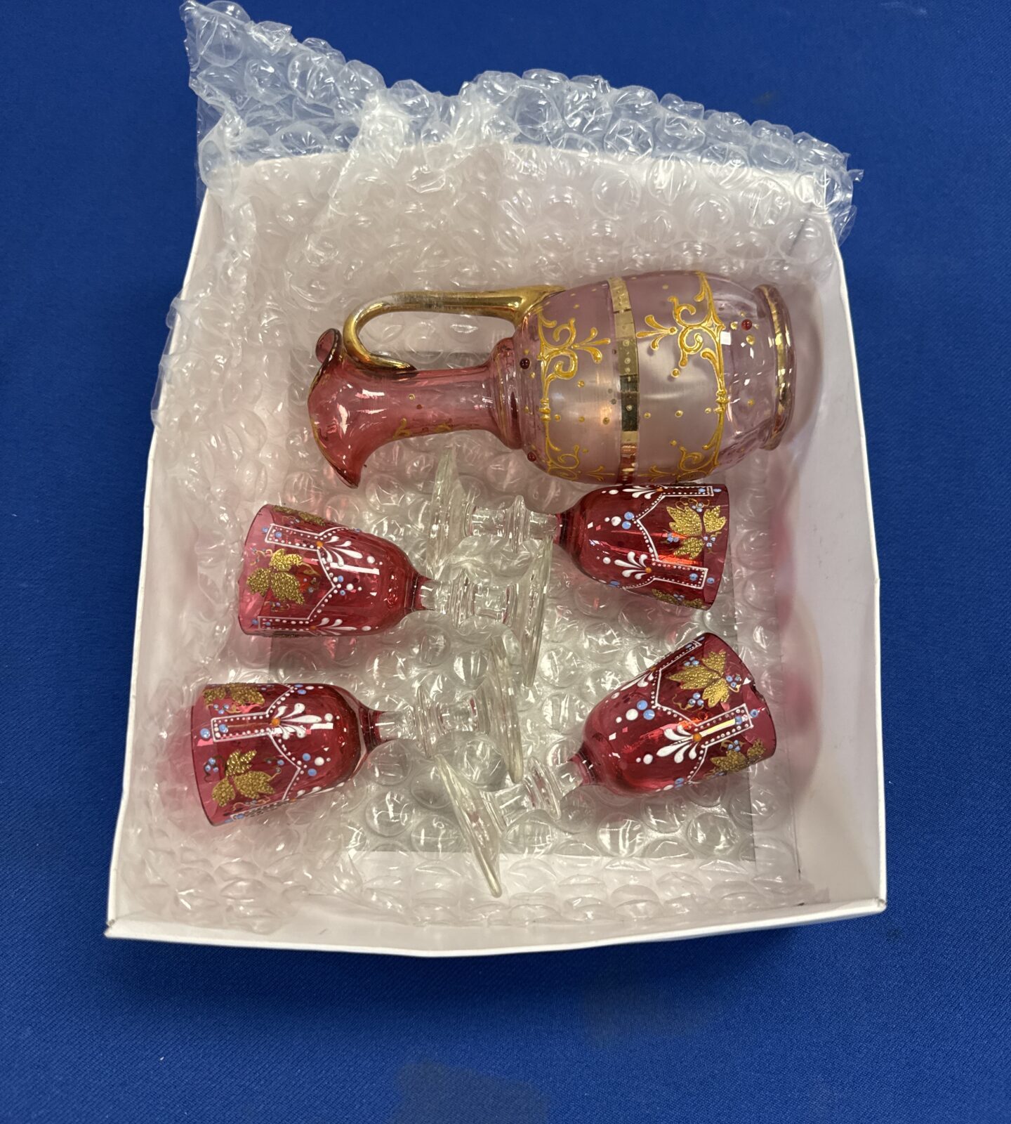 Vintage bohemian cranberry glass spirits serving jug with glasses (one glass has small chip on lip area)