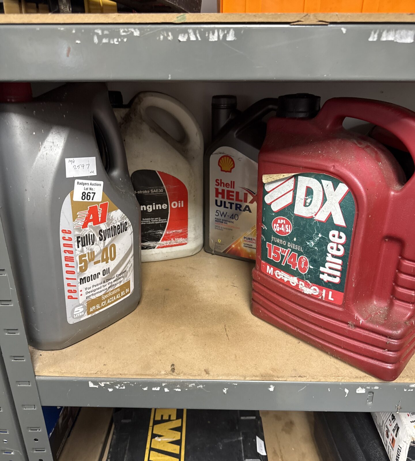 Four tubs of assorted engine oil (front 2 feel full, back 2 part used)