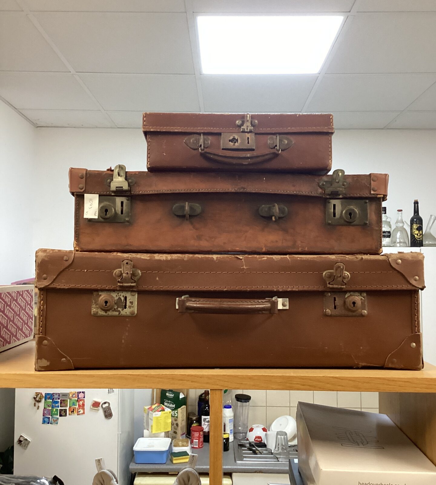 Three vintage brown leather suitcases