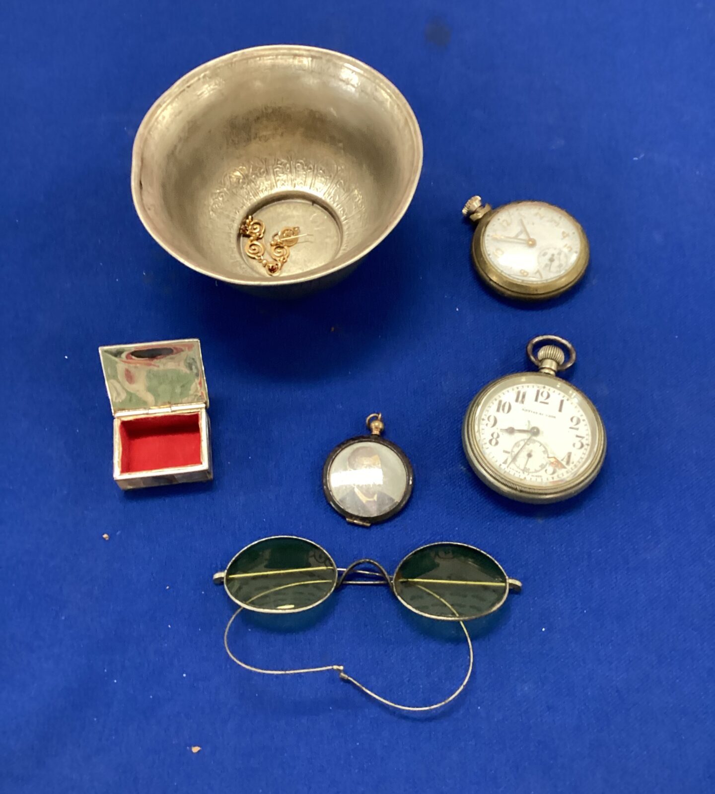 metal dish with two pocket watches and glasses