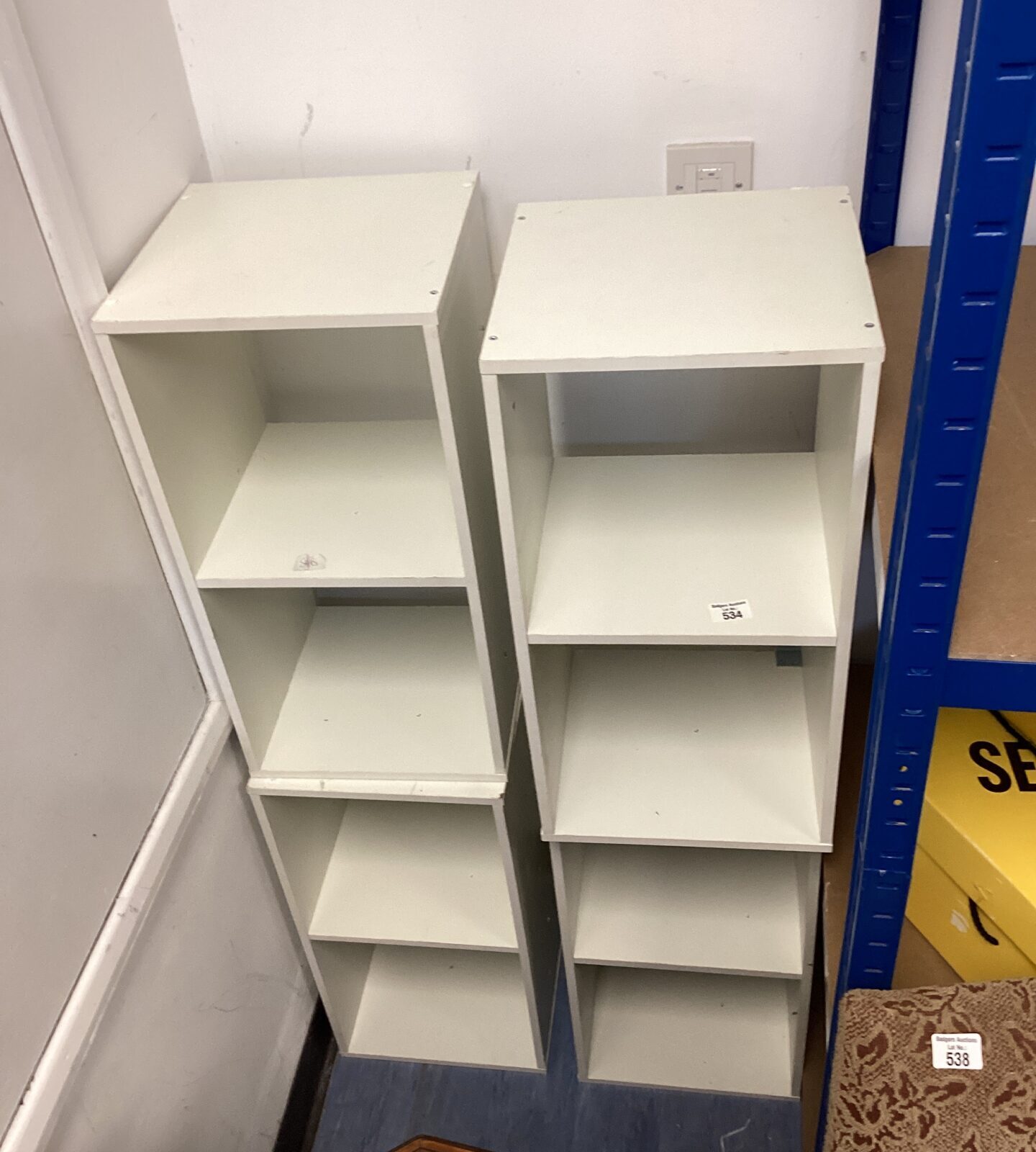 Four white shelving units