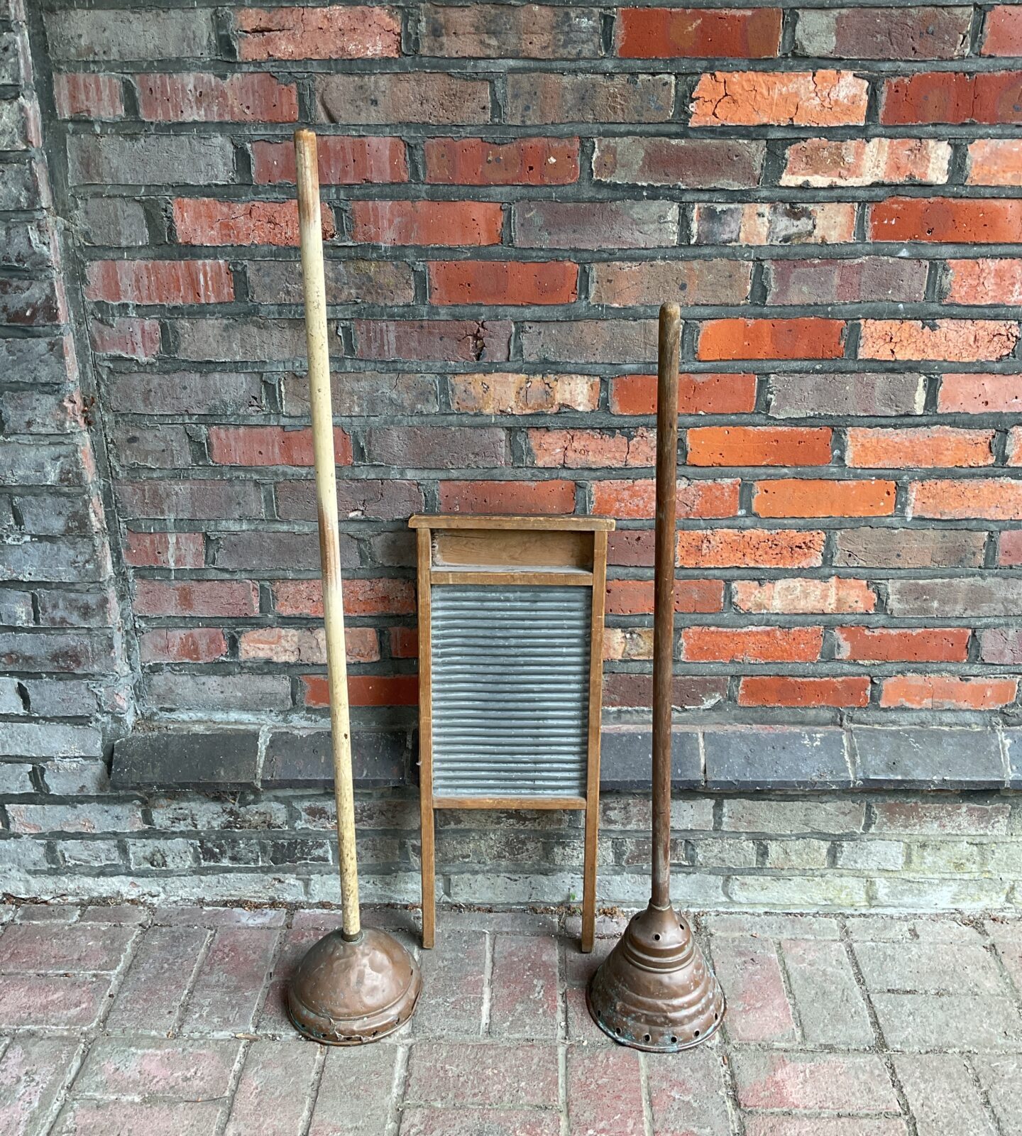 Two vintage copper washing dollies & wash board