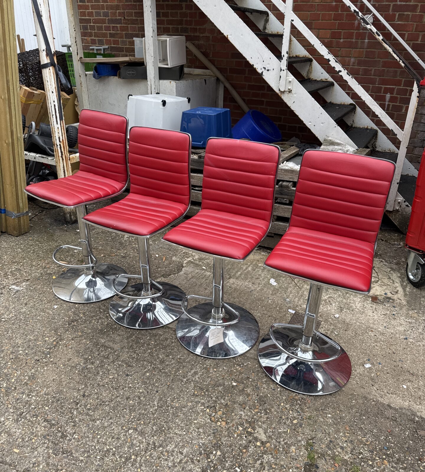 Set of four red faux leather & chrome bar stools