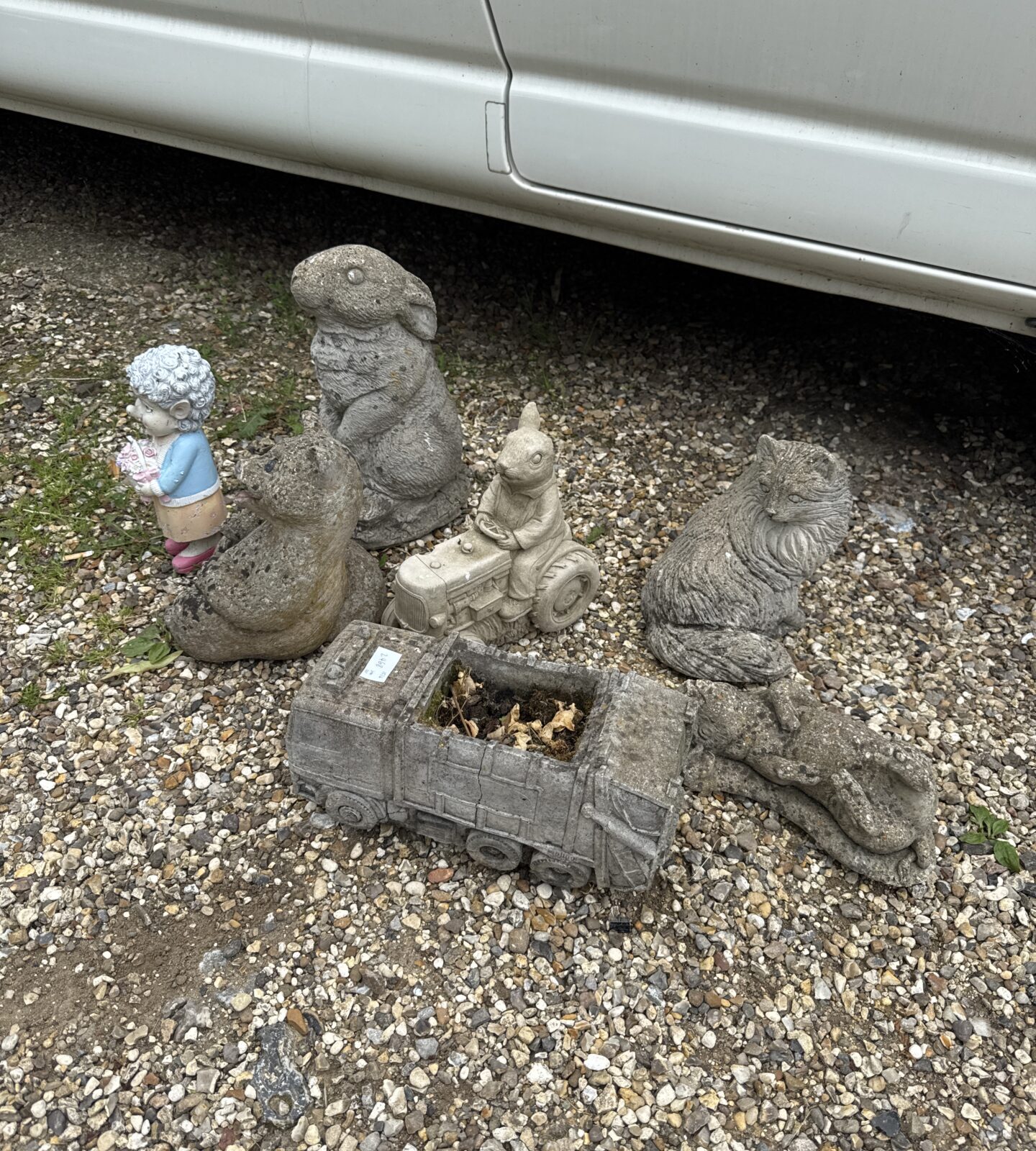 Selection of seven assorted concrete garden ornaments inc rabbits, cats & others - rabbit on tractor missing an ear