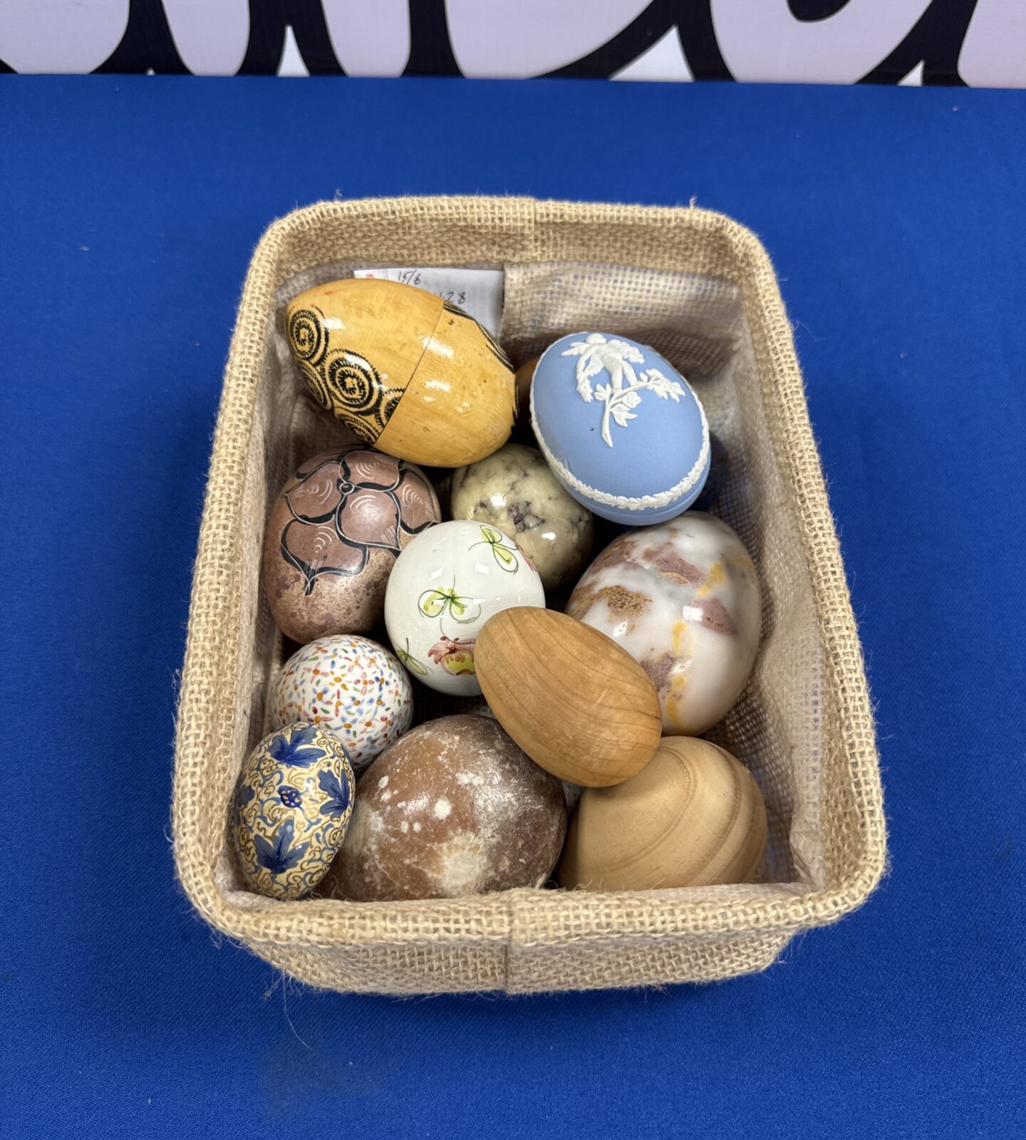 Small canvas tray of wooden & ceramic eggs inc one Wedgwood