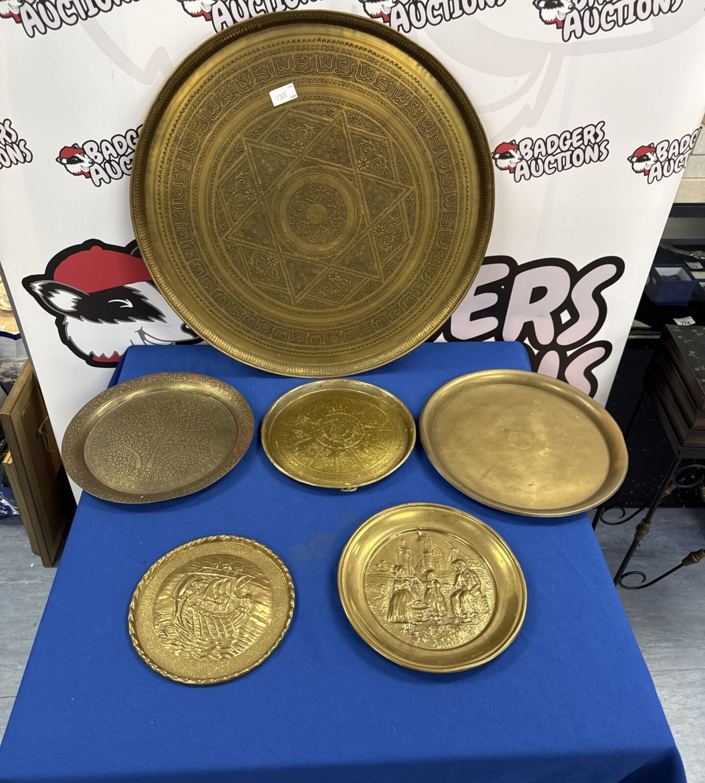 Six decorative brass chargers including large islamic charger