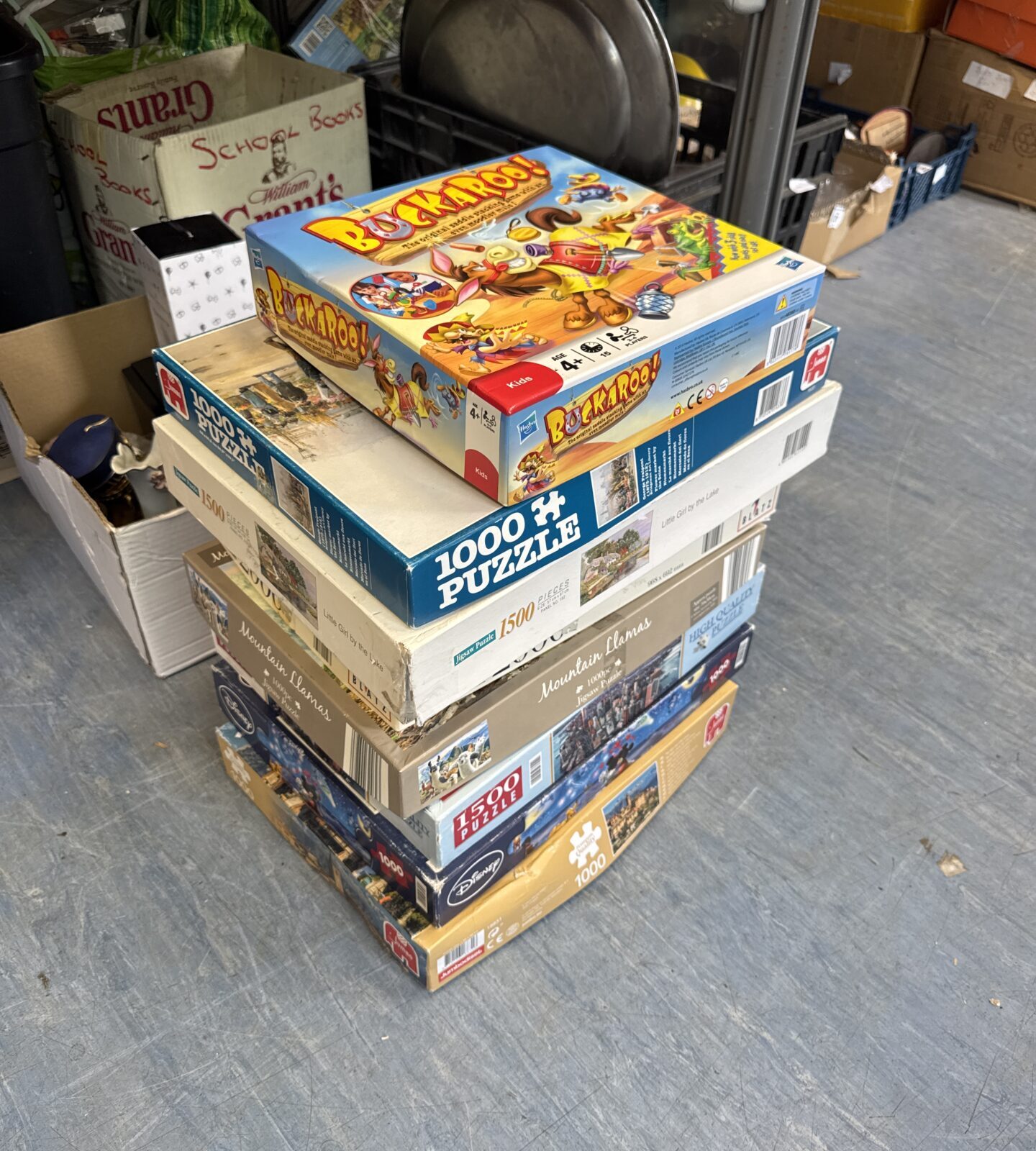 Bundle of assorted jigsaw puzzles & a buckaroo game