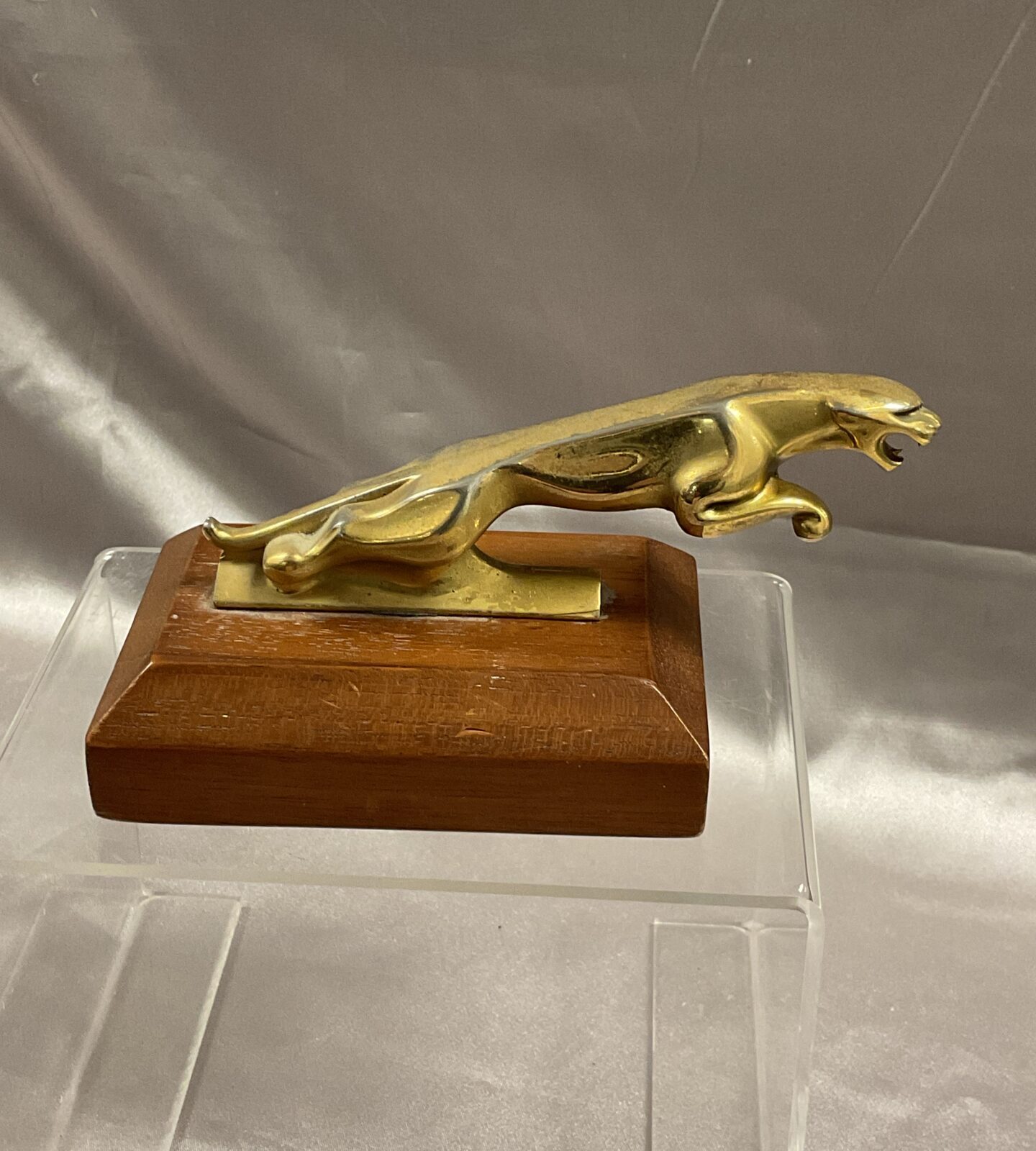 Small Goldtone Jaguar bonnet mascot on mahogany base