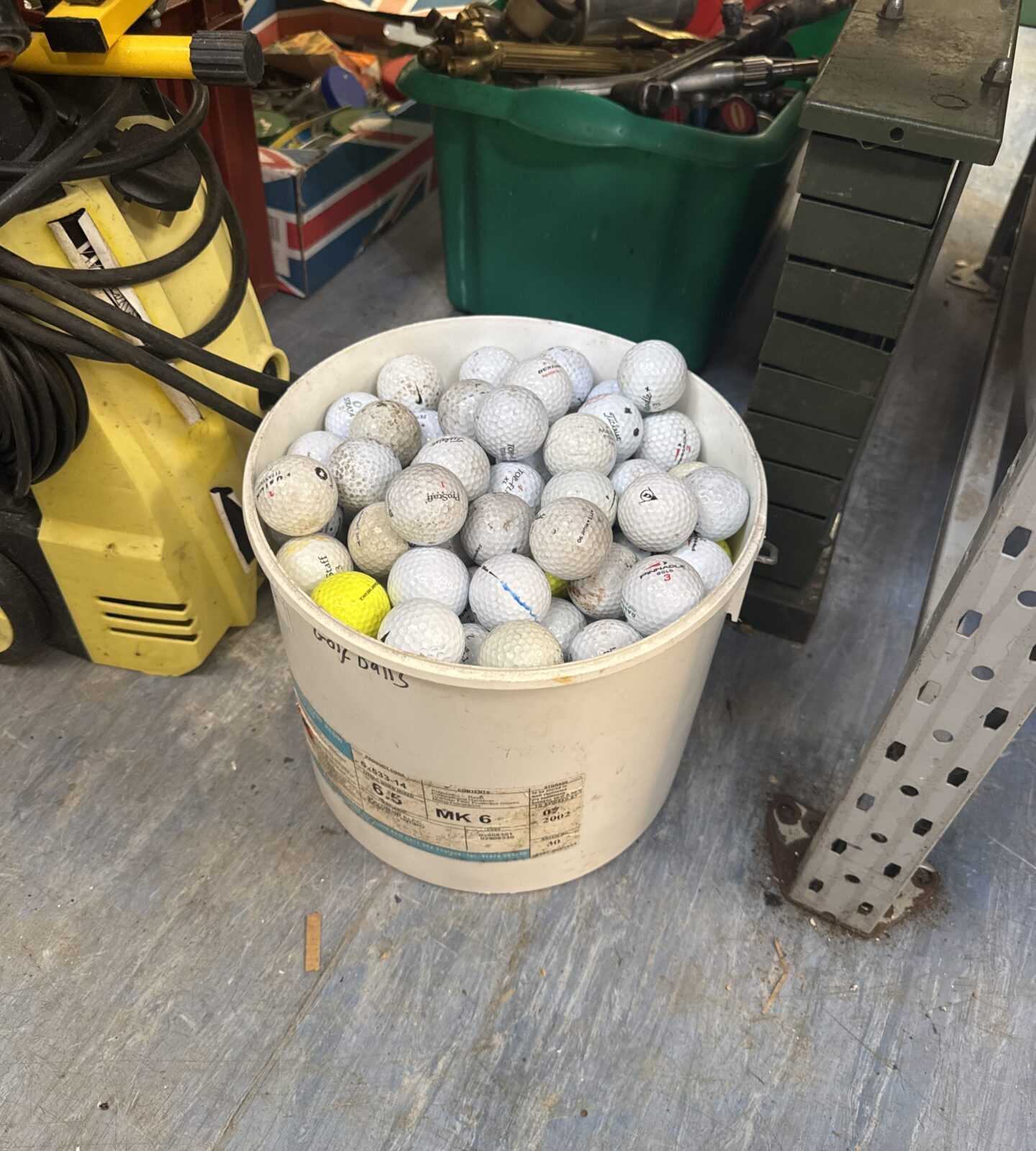 Large bucket of mixed golf balls