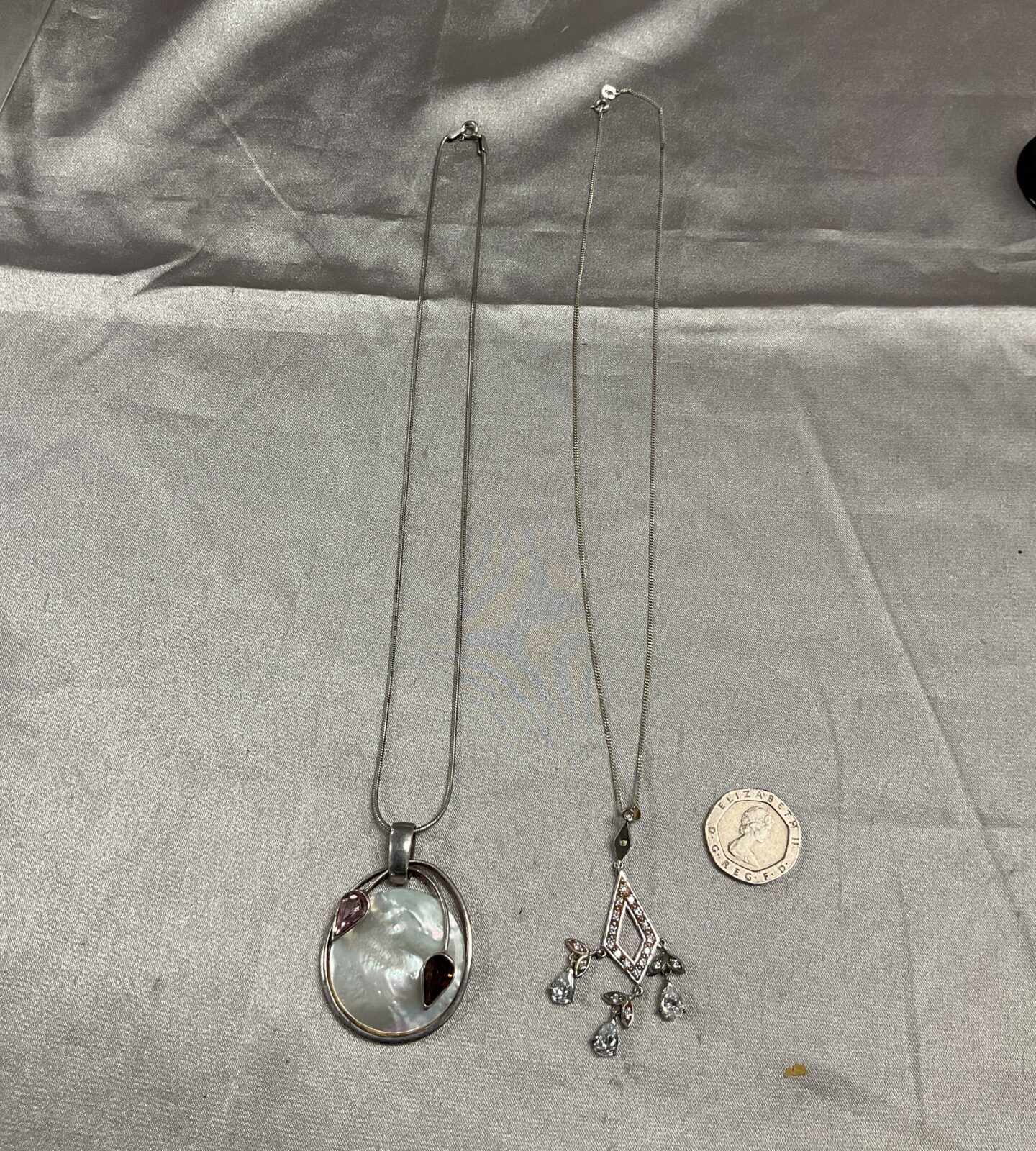 Two 18” silver necklaces with mother of pearl pendant and three stone pendants