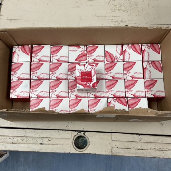 Quantity of Clarins Aroma Eau Dynamistante scented candles in boxes.