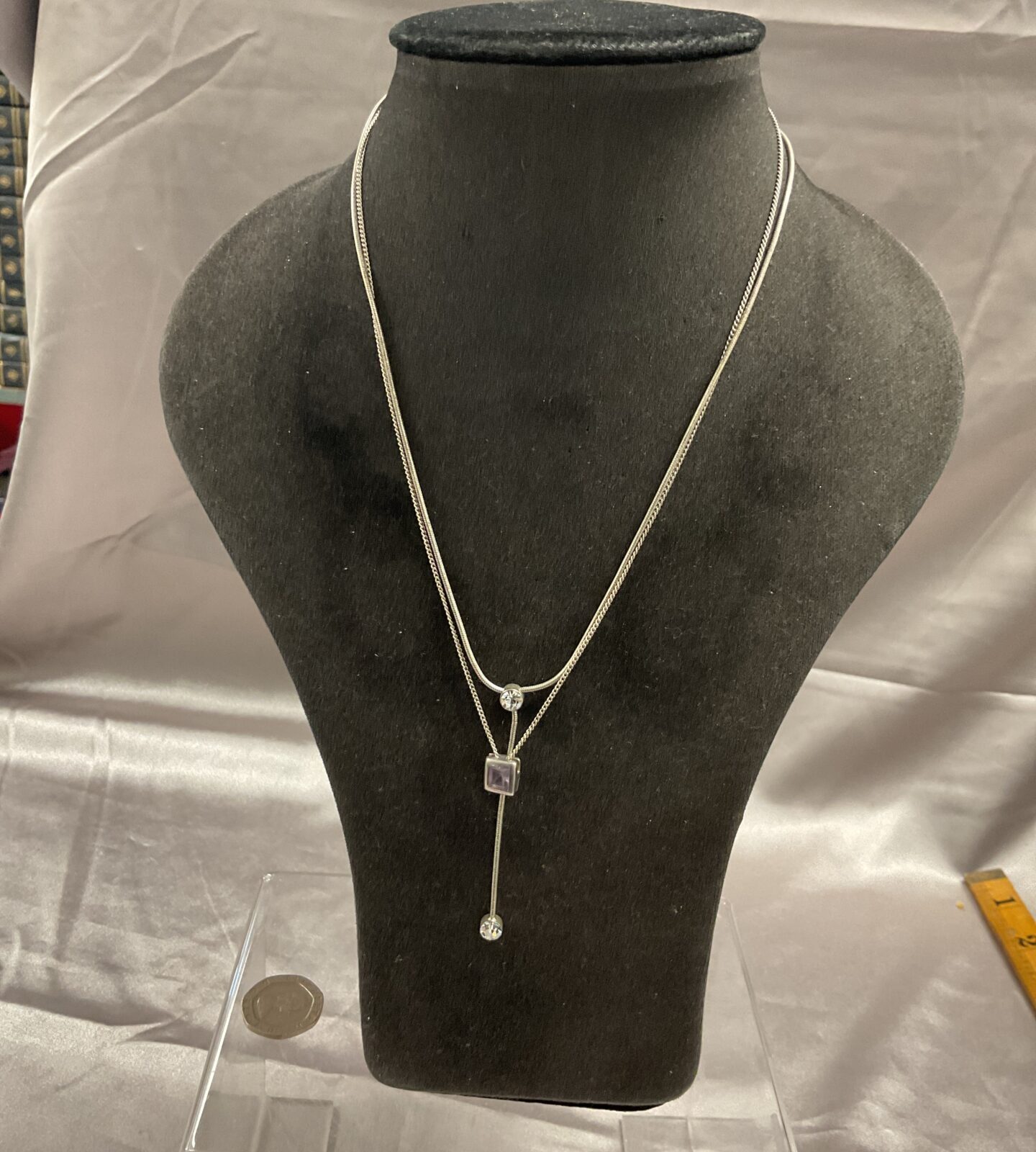 Two silver necklaces one set with amethyst and other with two white stones