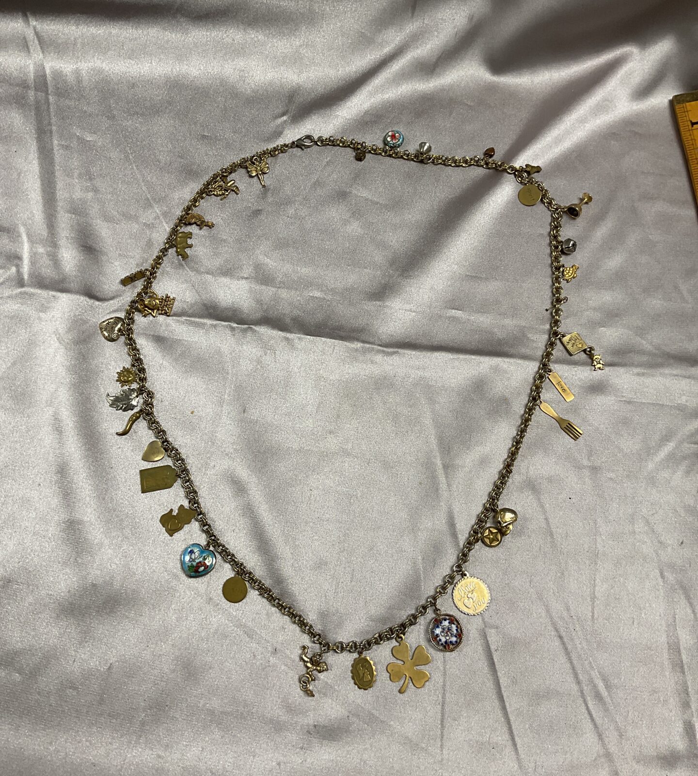 Vintage mid century charm necklace, including enamel skull and cherub examples x  36 32 inch long