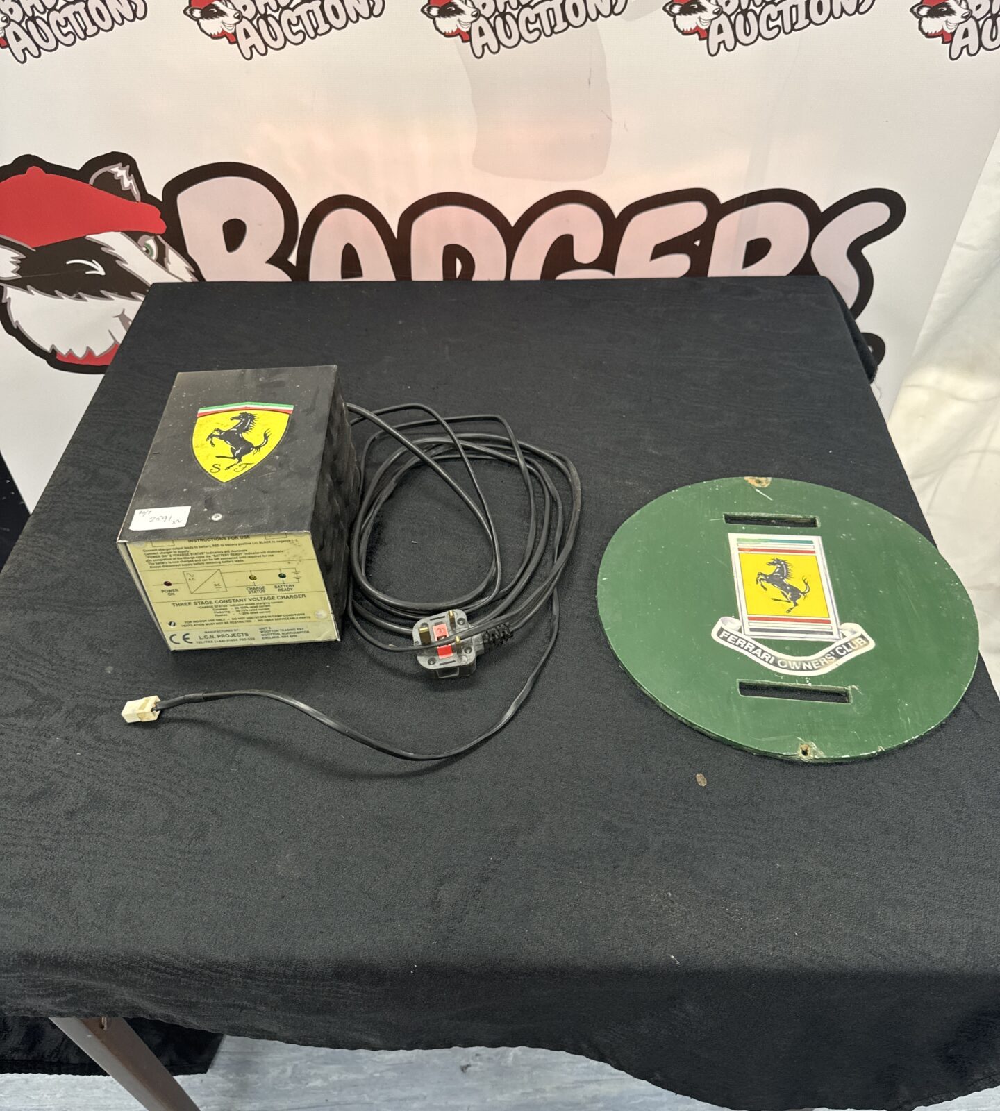 L C N projects trickle charger with wooden plaque displaying ferrari owners club sticker