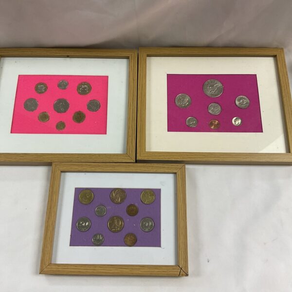 Framed coin sets featuring USA, French, and Belgian currency.