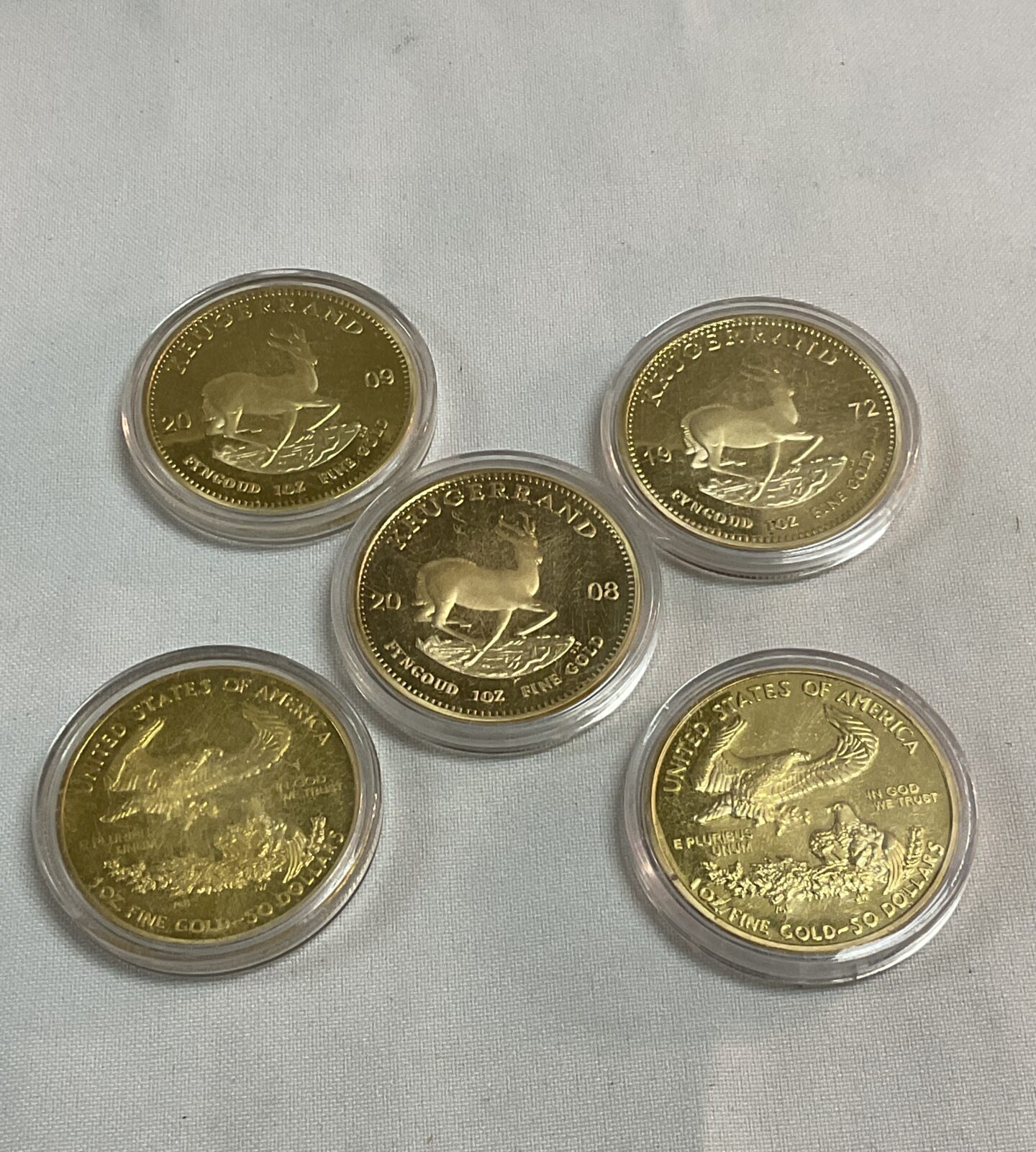 Three Replica Commemorative Krugerands and two USA 50 dollar coins
