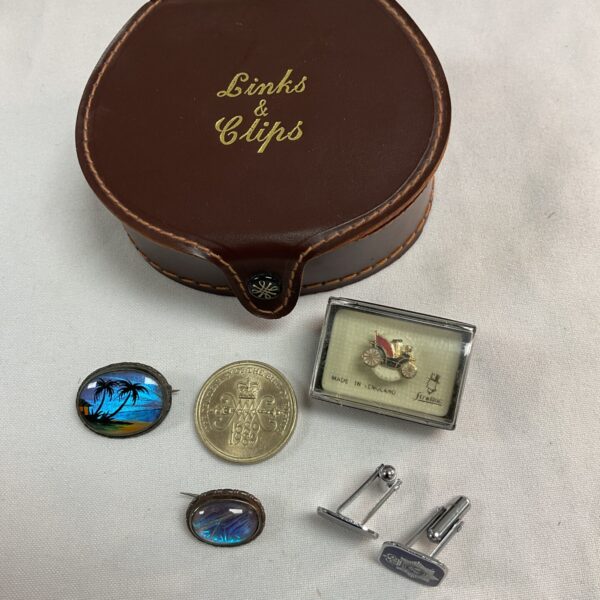 Leather links and clips box with two silver abalone brooches £2 coin cufflinks and car pin badge
