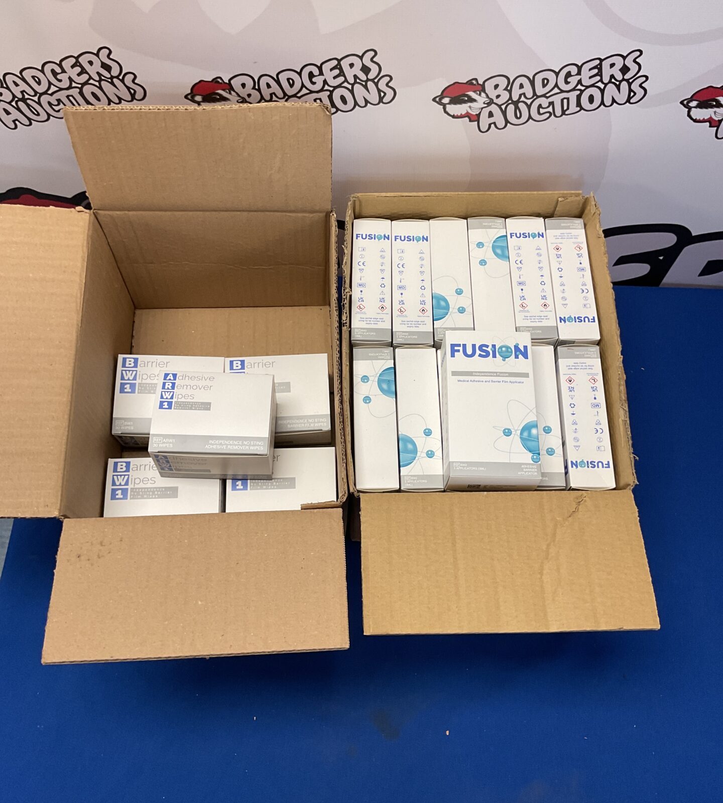 Box of fusion medical adhesive and barrier film applicators and box of barrier and adhesive remove wipes