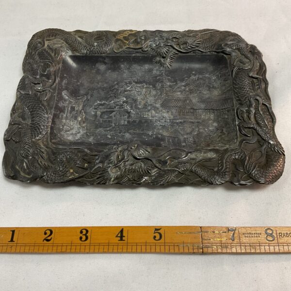 Antique pewter Japanese relief work with dragons encircling the edges and detailed landscape scene in the centre likely from Meiji period some damage to one corner