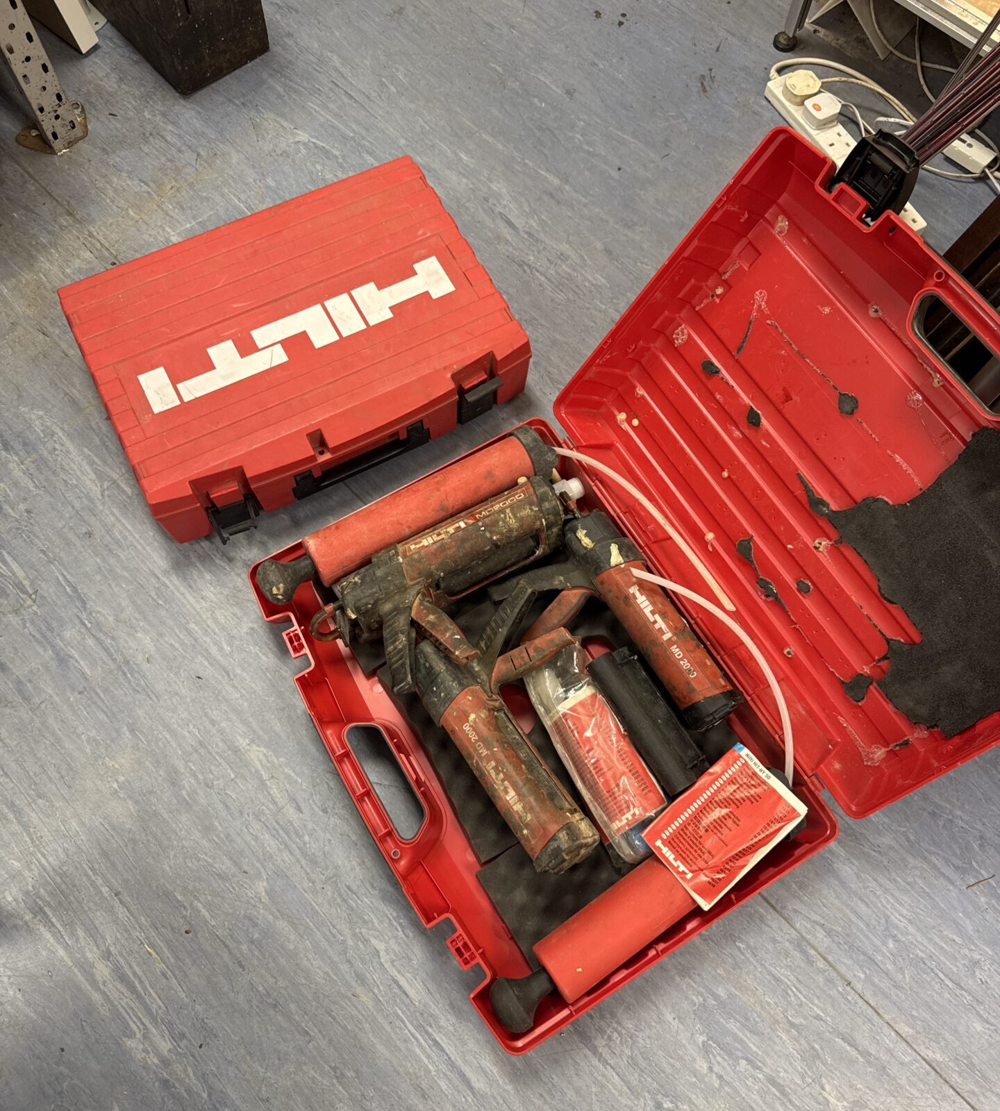 Selection of hilti tools inc md2000 sealant guns & an empty Hilti case