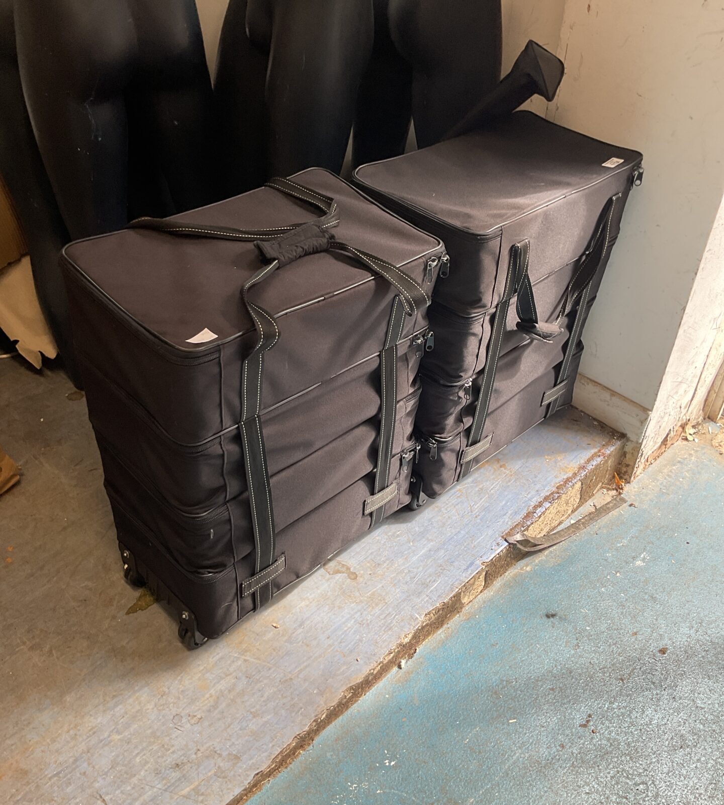 Two black wheeled storage cases/ shoe sample case