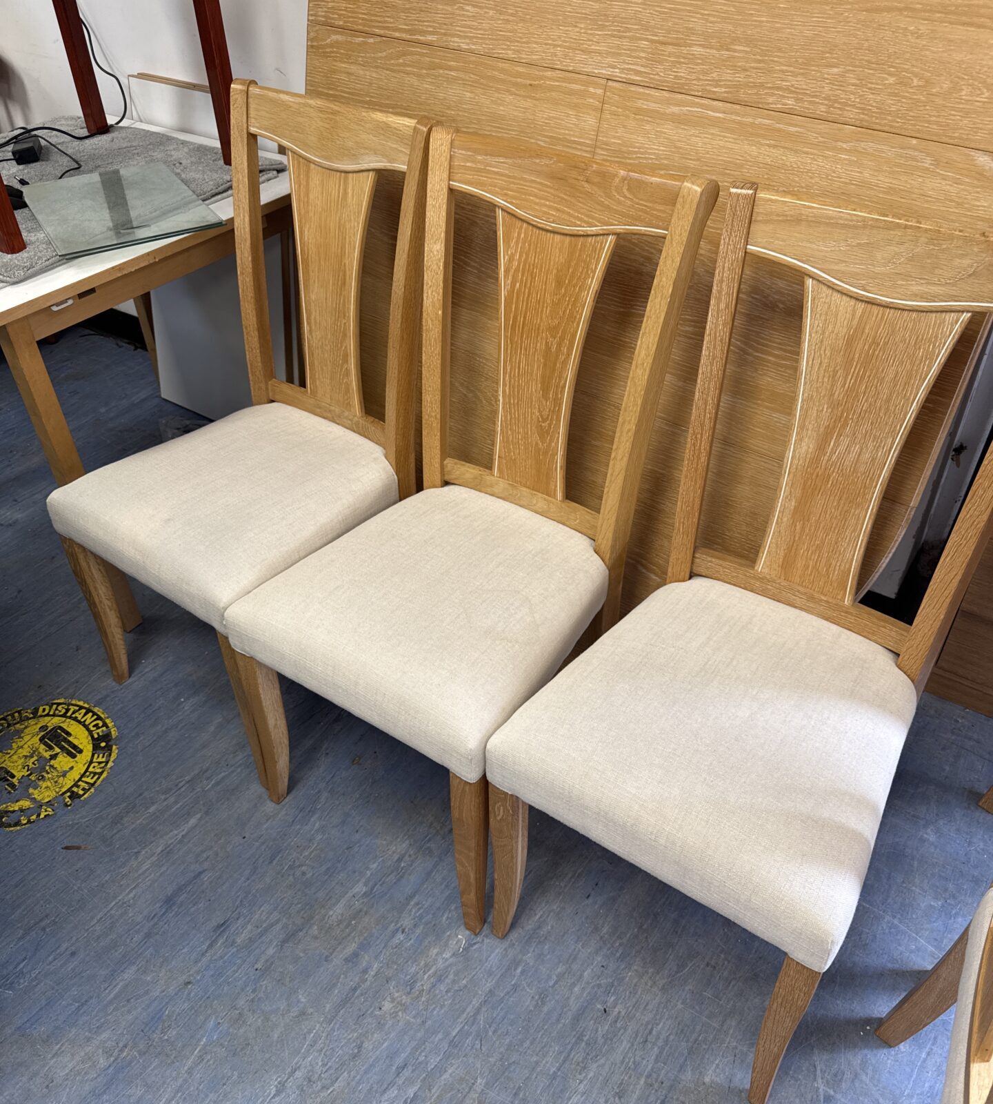 Light oak modern dining table with removable centre extension sections & six cream coloured fabric chairs 65” length fully extended x 47.5” width - one chair has light coffee stain - Image 3