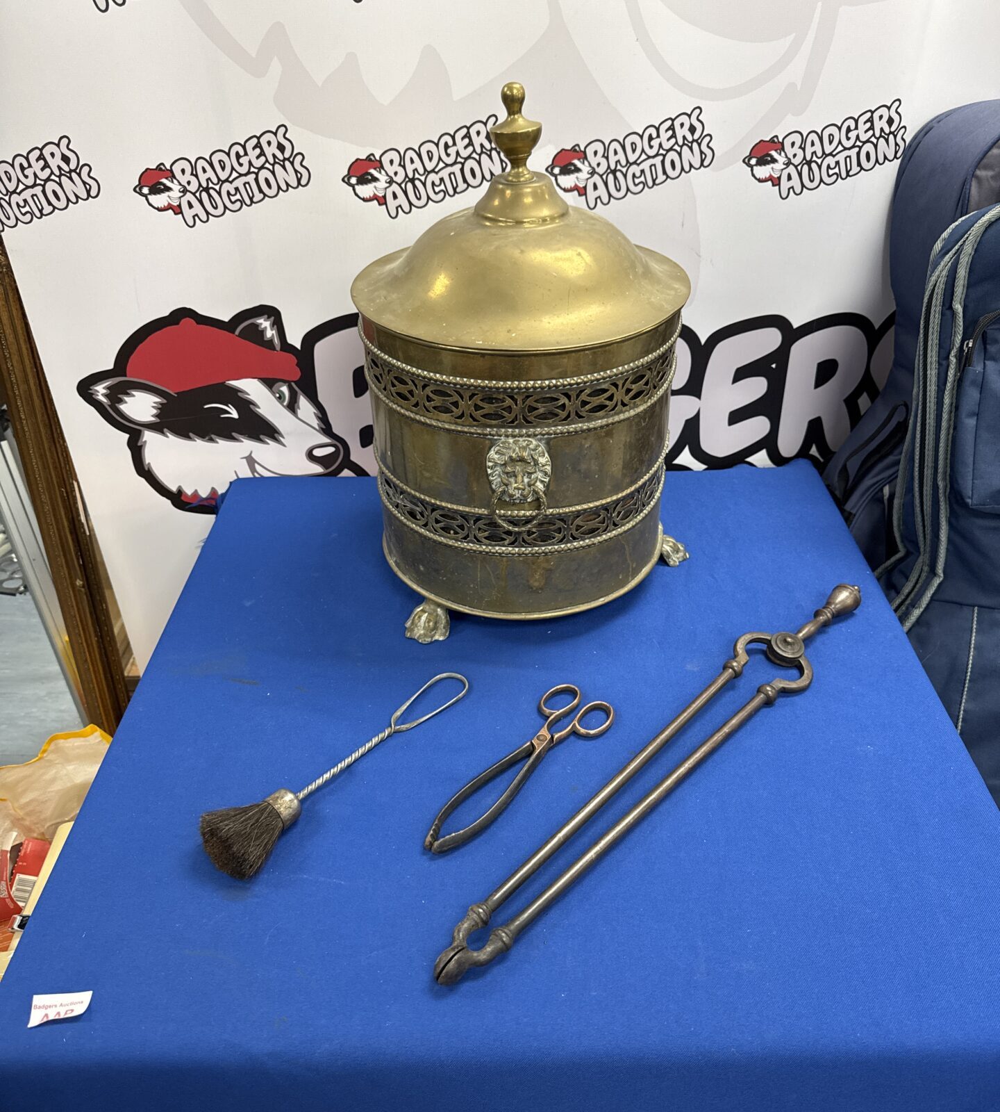 Vintage brass fireside coal bucket with lions head & claw foot detailing, two pairs of tongs & a brush