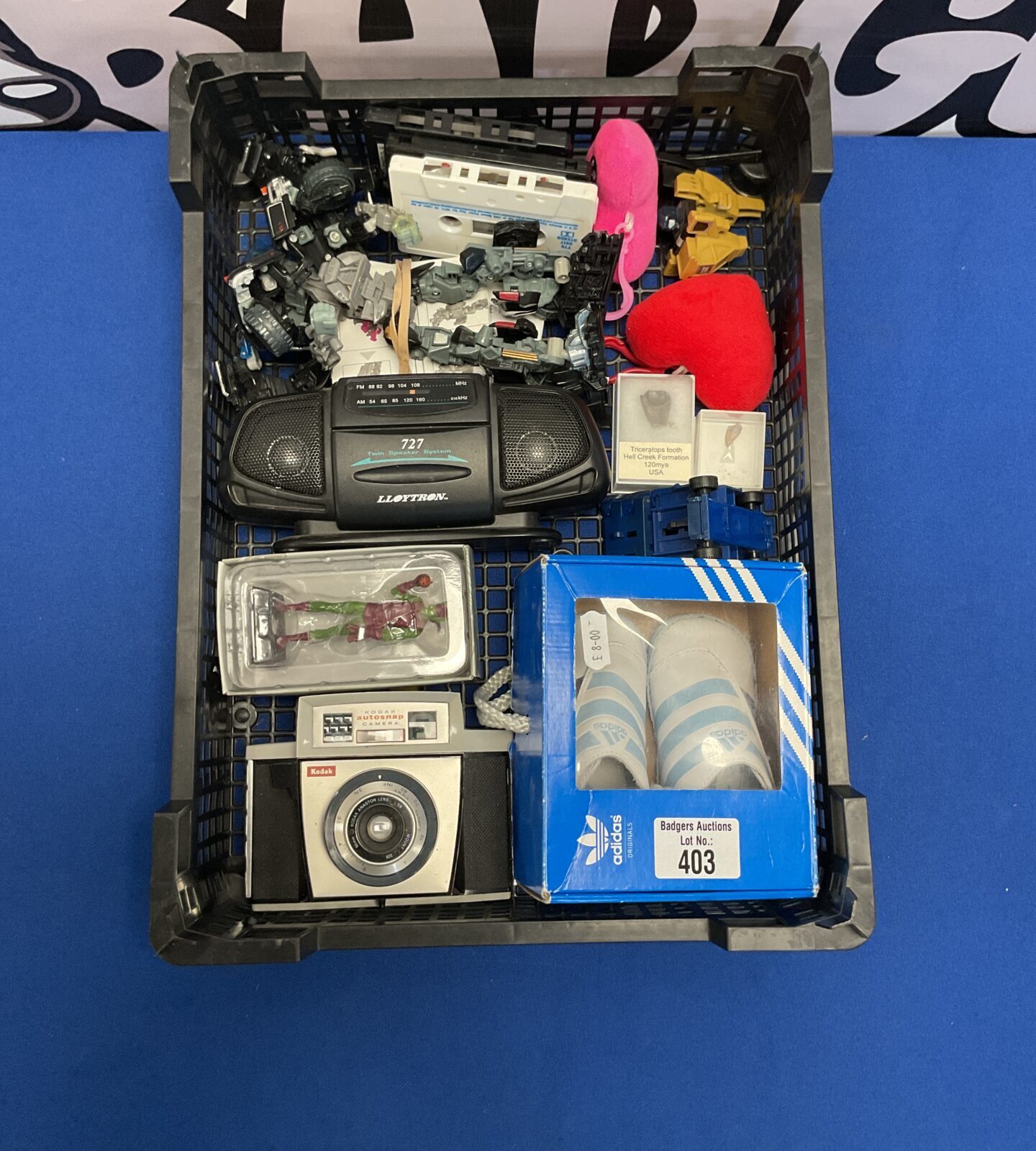 Box of mixed collectables and other items inc addidas size 3y,  triceratops and raptors tooth, kodak camera and transformer's