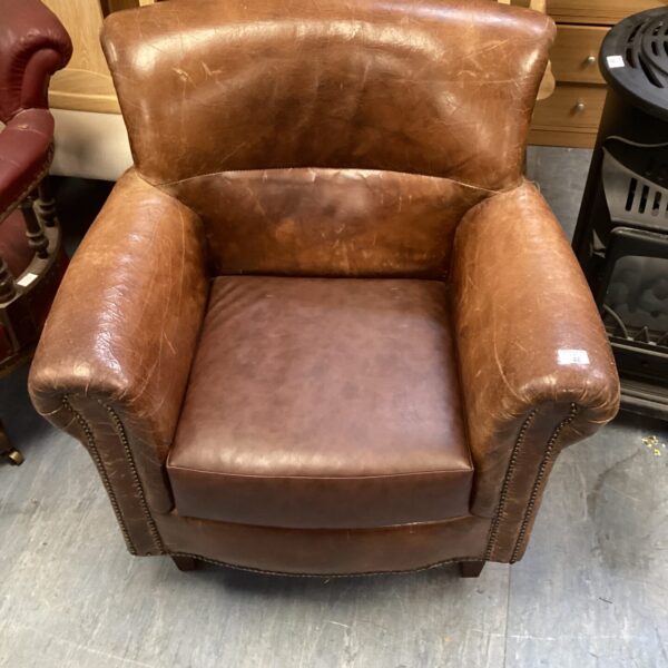 Brown vintage leather armchair with rolled arms.