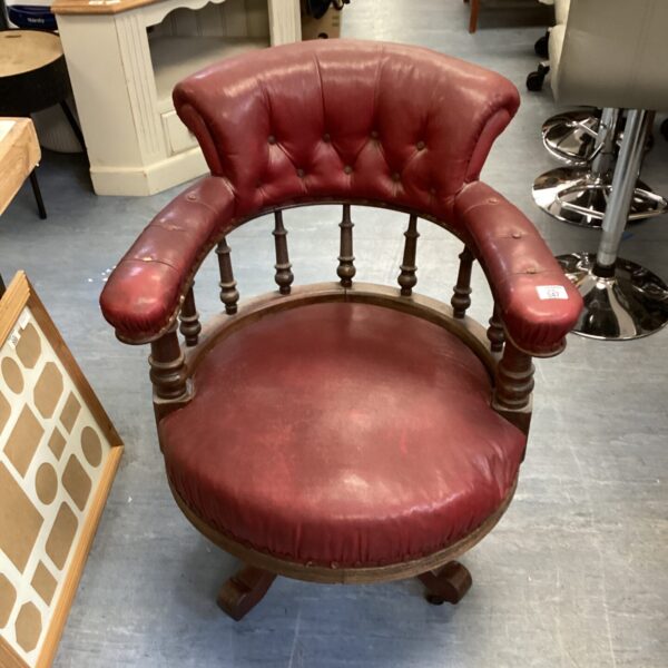 Vintage red leather swivel chair with wooden base.
