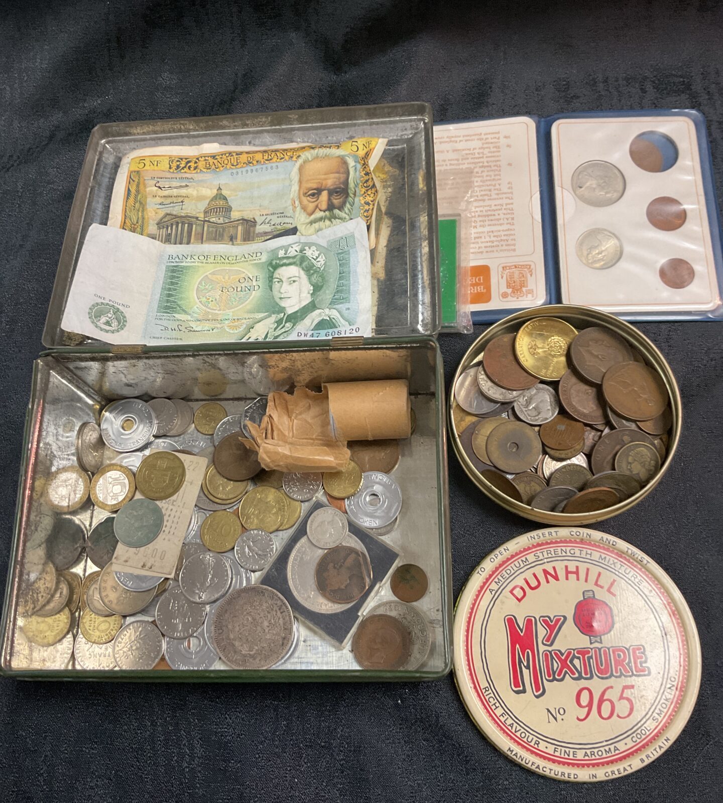 Tin of assorted coins and two banknotes