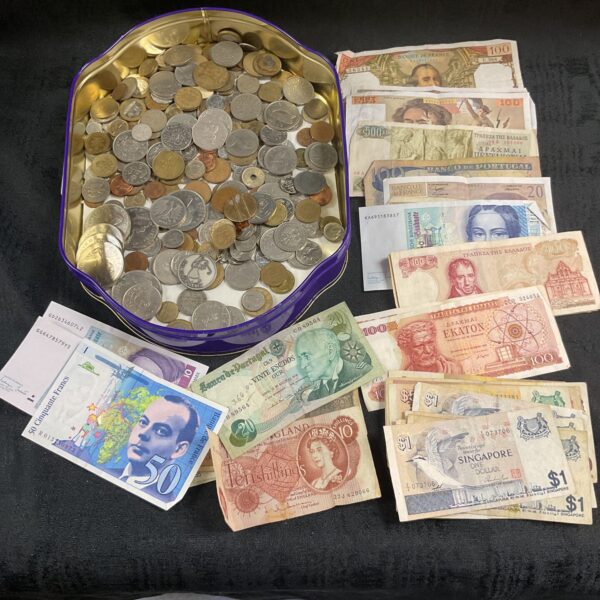 Assorted coins and banknotes presented in a decorative tin.