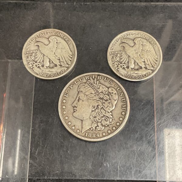 Vintage 1884 Morgan Silver Dollar and silver half dollar coins.