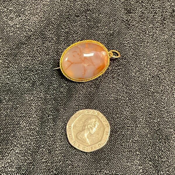 Vintage agate pendant brooch with warm orange tones.