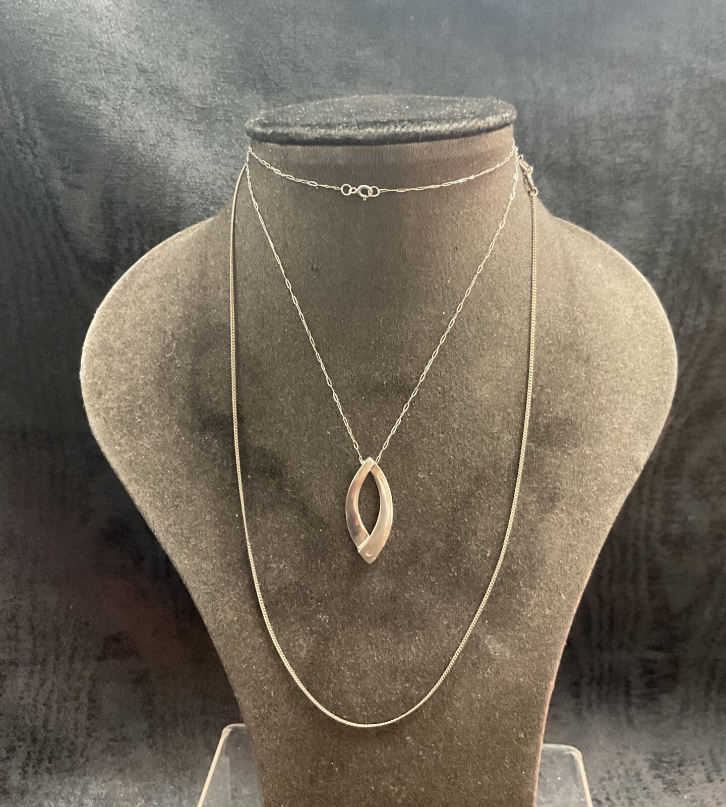 Two silver chain necklaces one with crossover pendant